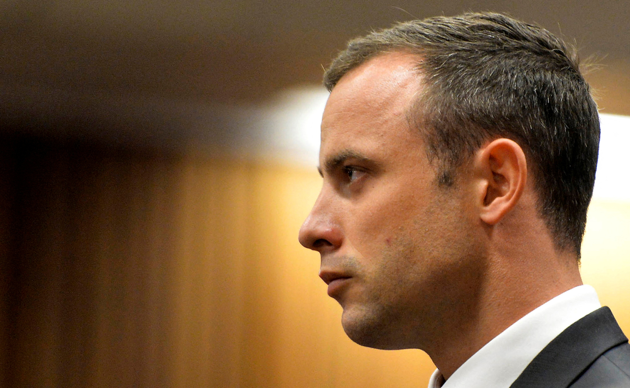FILE PHOTO: Olympic and Paralympic track star Oscar Pistorius stands in the dock during his trial at the North Gauteng High Court in Pretoria March 3, 2014. REUTERS/Herman Verwey/Pool/File Photo
