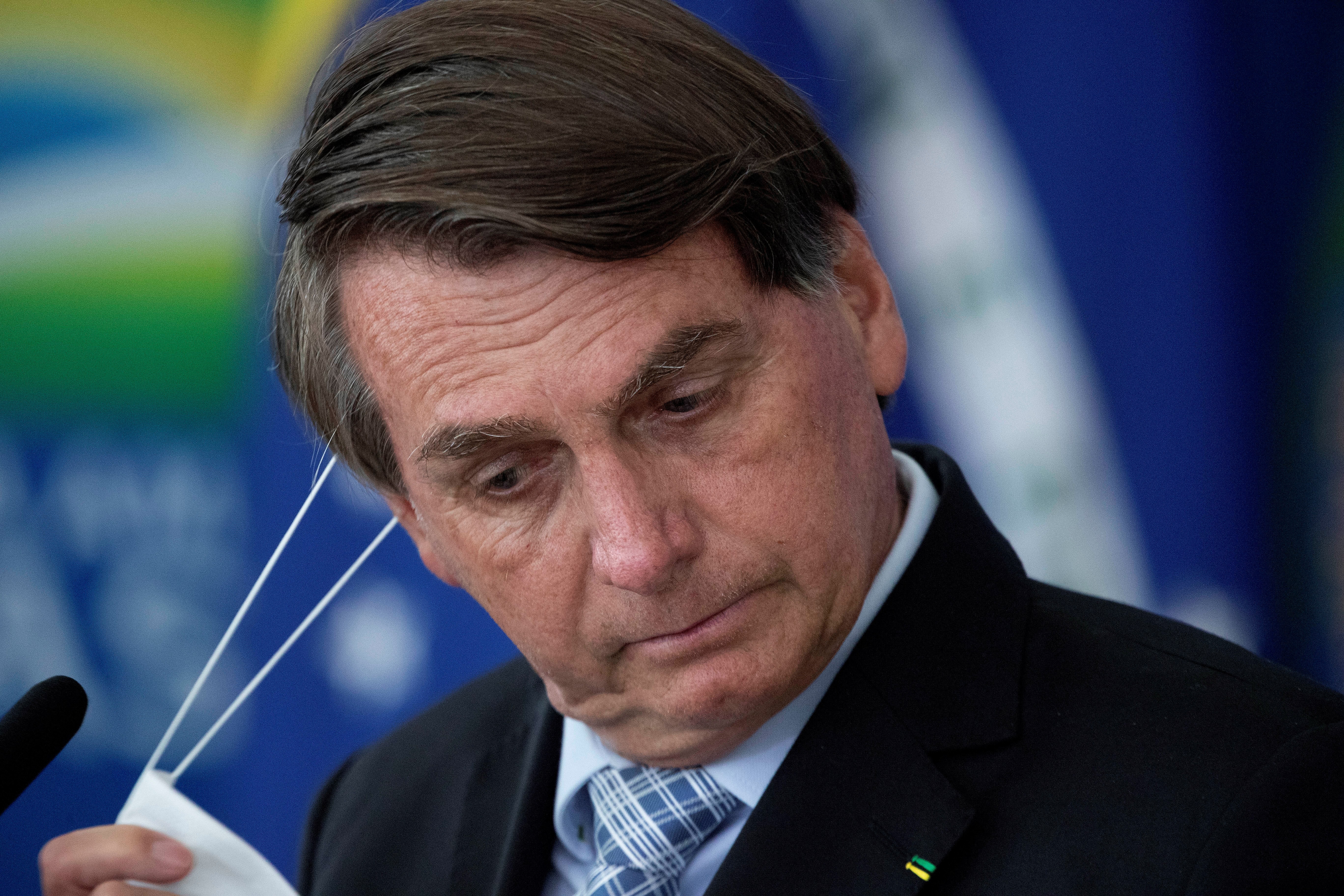 El presidente de Brasil, Jair Bolsonaro, reacciona mientras sanciona los proyectos de ley que amplían la capacidad de adquisición de vacunas por parte del Gobierno Federal hoy, en el Palacio de Planalto, en Brasilia (Brasil). EFE/ Joédson Alves
