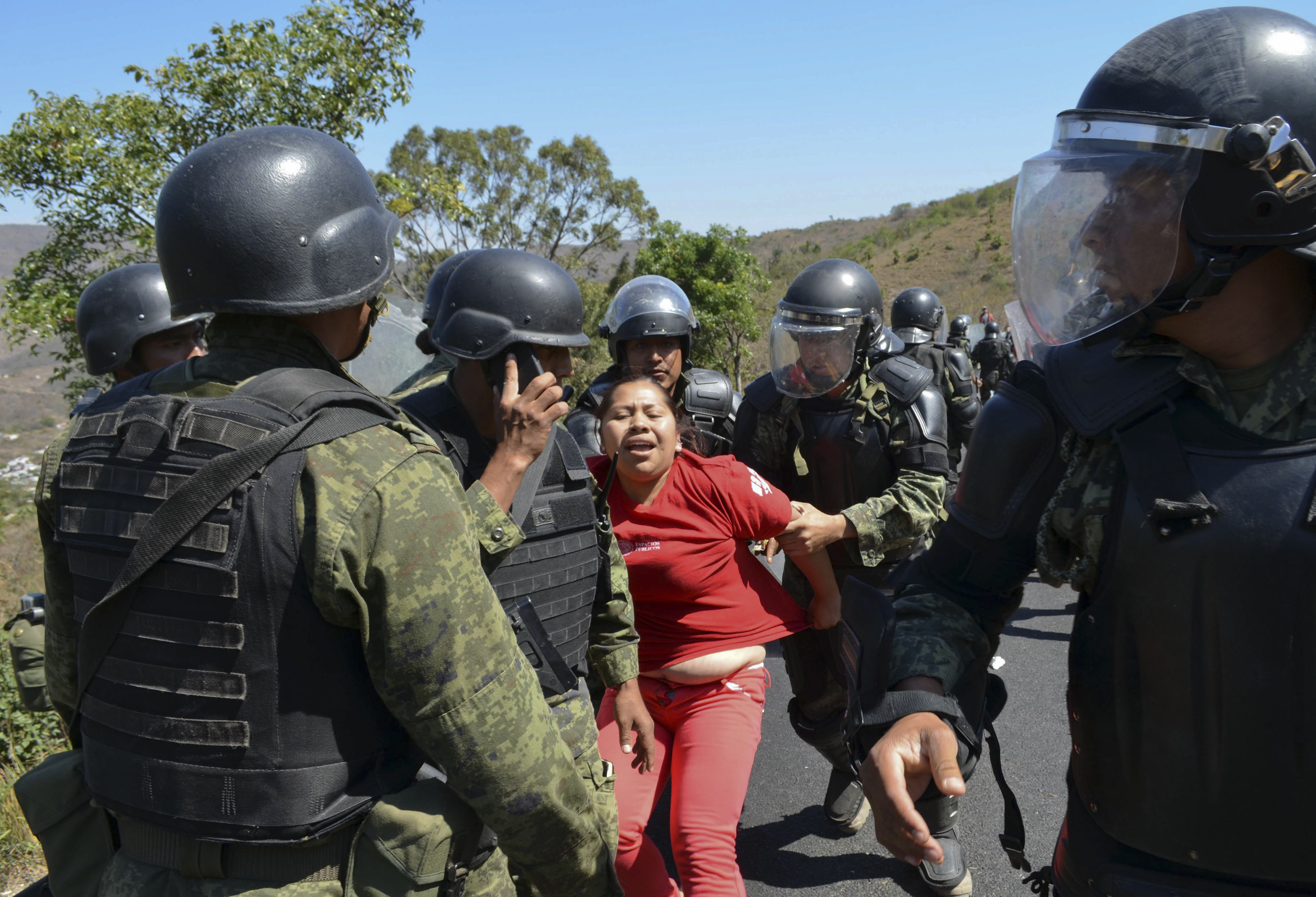 La policía militar del ejército mexicano detiene a una mujer, el viernes 6 de febrero de 2015, en un vecindario de la ciudad de Chilpancingo, México. (AP Foto/Alejandrino González, Archivo)