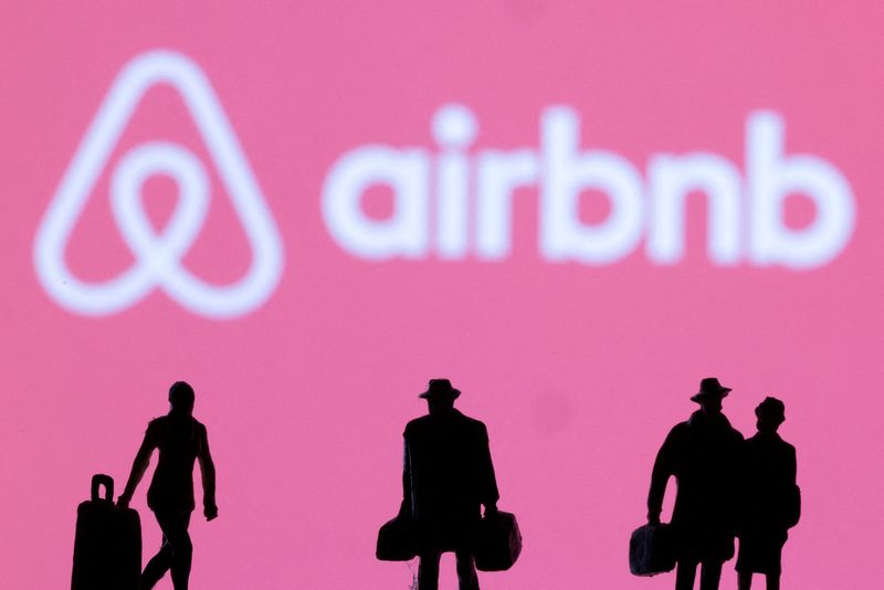 FILE PHOTO.  Illustration image of figures next to the Airbnb logo.  February 27, 2022. REUTERS/Dado Ruvic