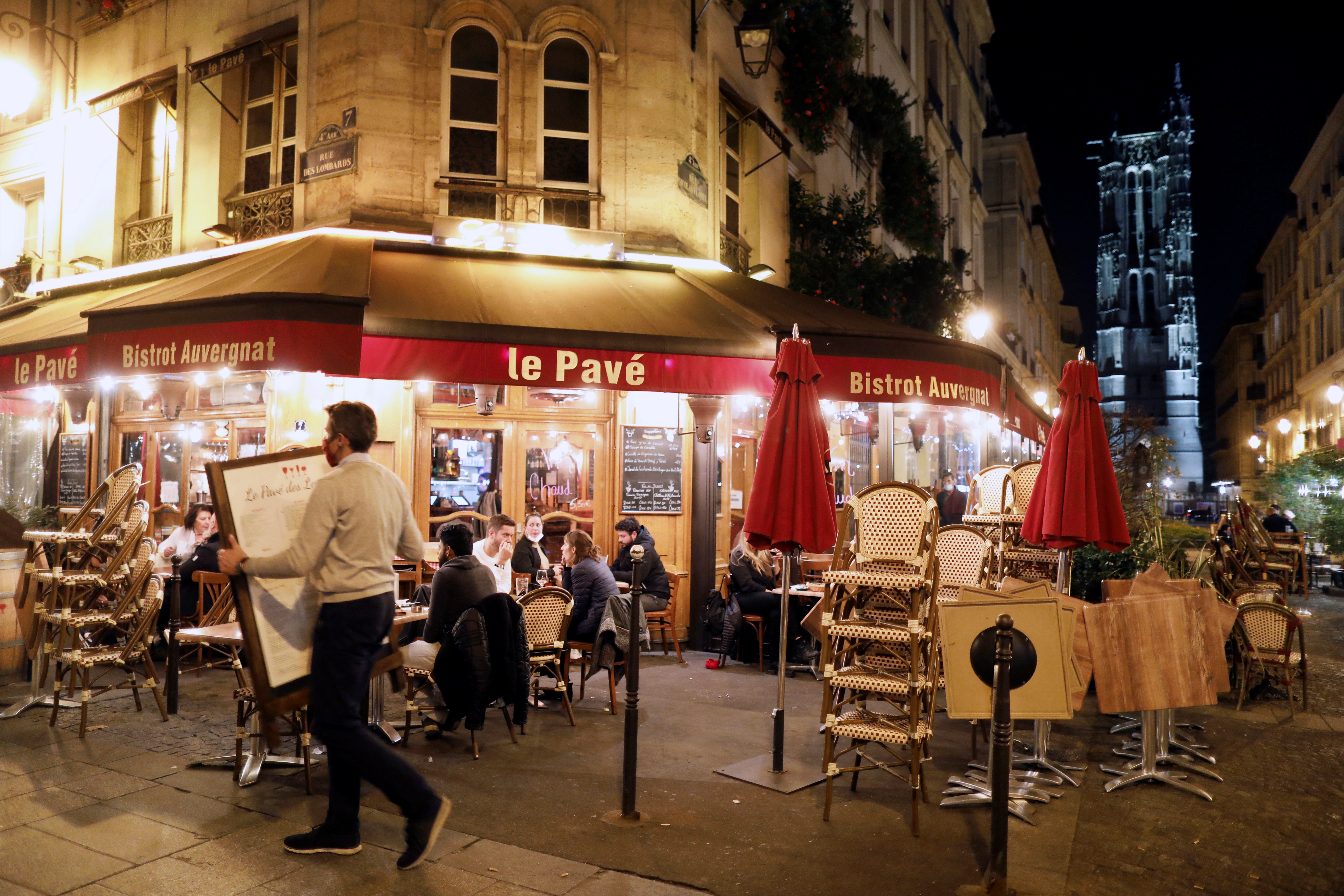 Un empleado cierra un restaurante en París, de acuerdo con las nuevas restricciones para evitar los contagios de COVID-19.   REUTERS/Charles Platiau