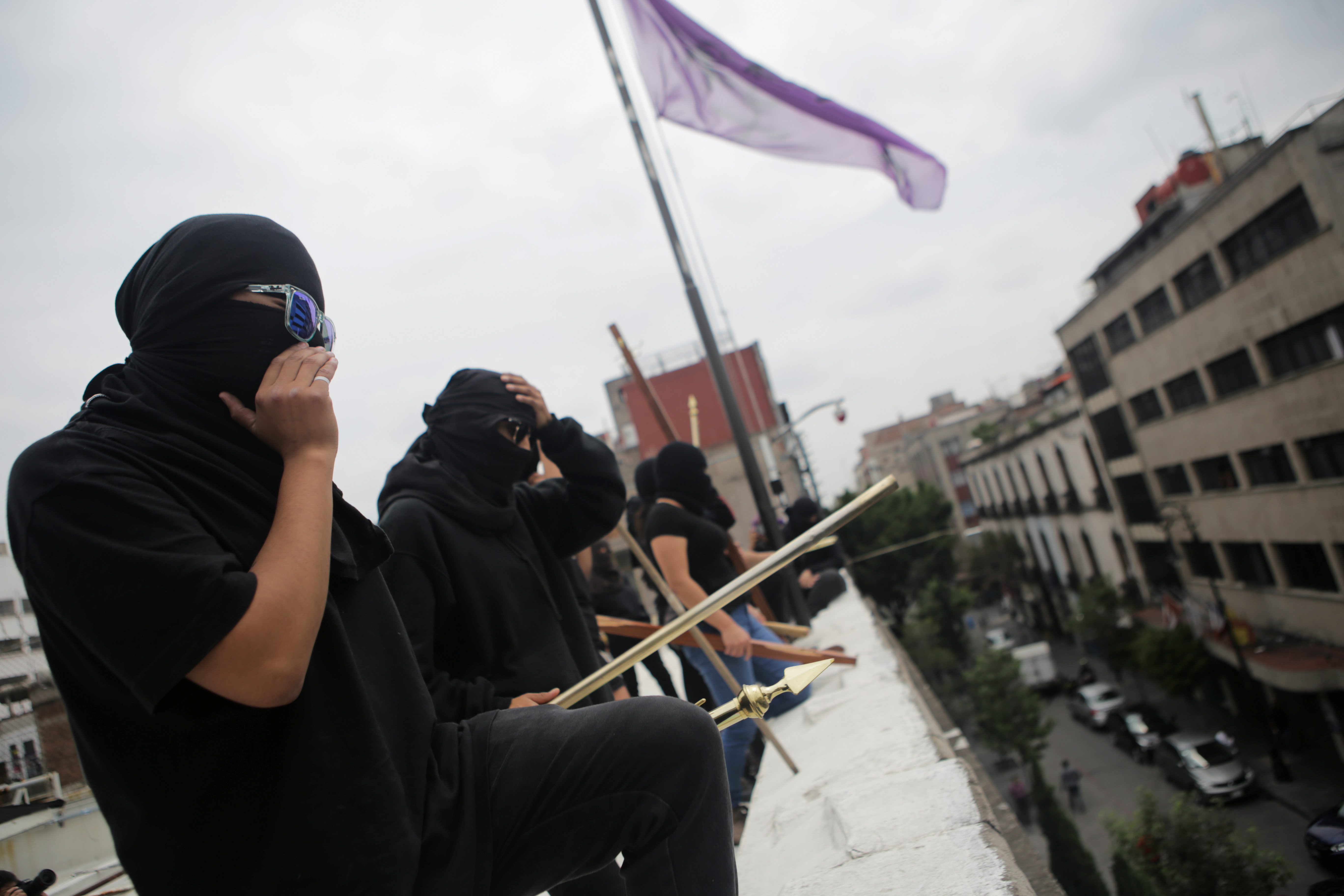 Integrante de un colectivo feminista mira por encima del techo tras ocupar las instalaciones del edificio de la Comisión Nacional de Derechos Humanos, en apoyo a víctimas de violencia de género, México 10 de septiembre de 2020. Foto tomada el 10 de septiembre de 2020.