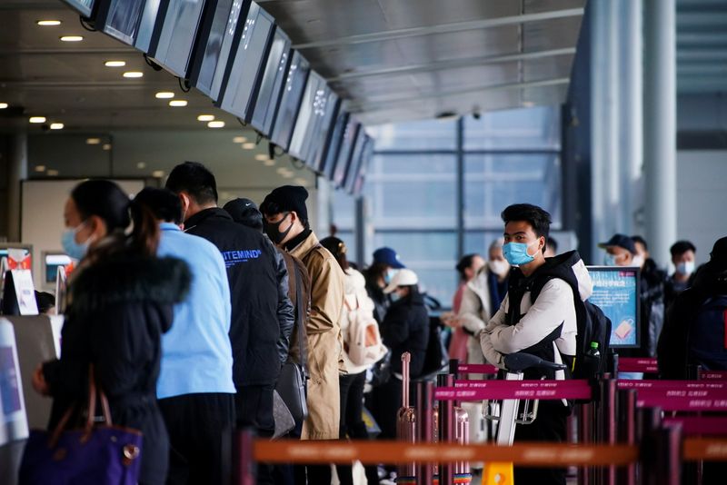 Travelers wearing face masks while waiting for the coronavirus (COVID-19) epidemic at the check-in counters at Shanghai Hongqiao International Airport in Shanghai, China