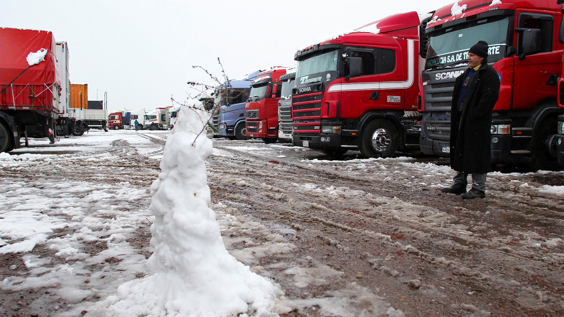 Los camioneros se entretienen haciendo muñecos de nieve así la estadía se hace más divertida y la espera un poco más corta