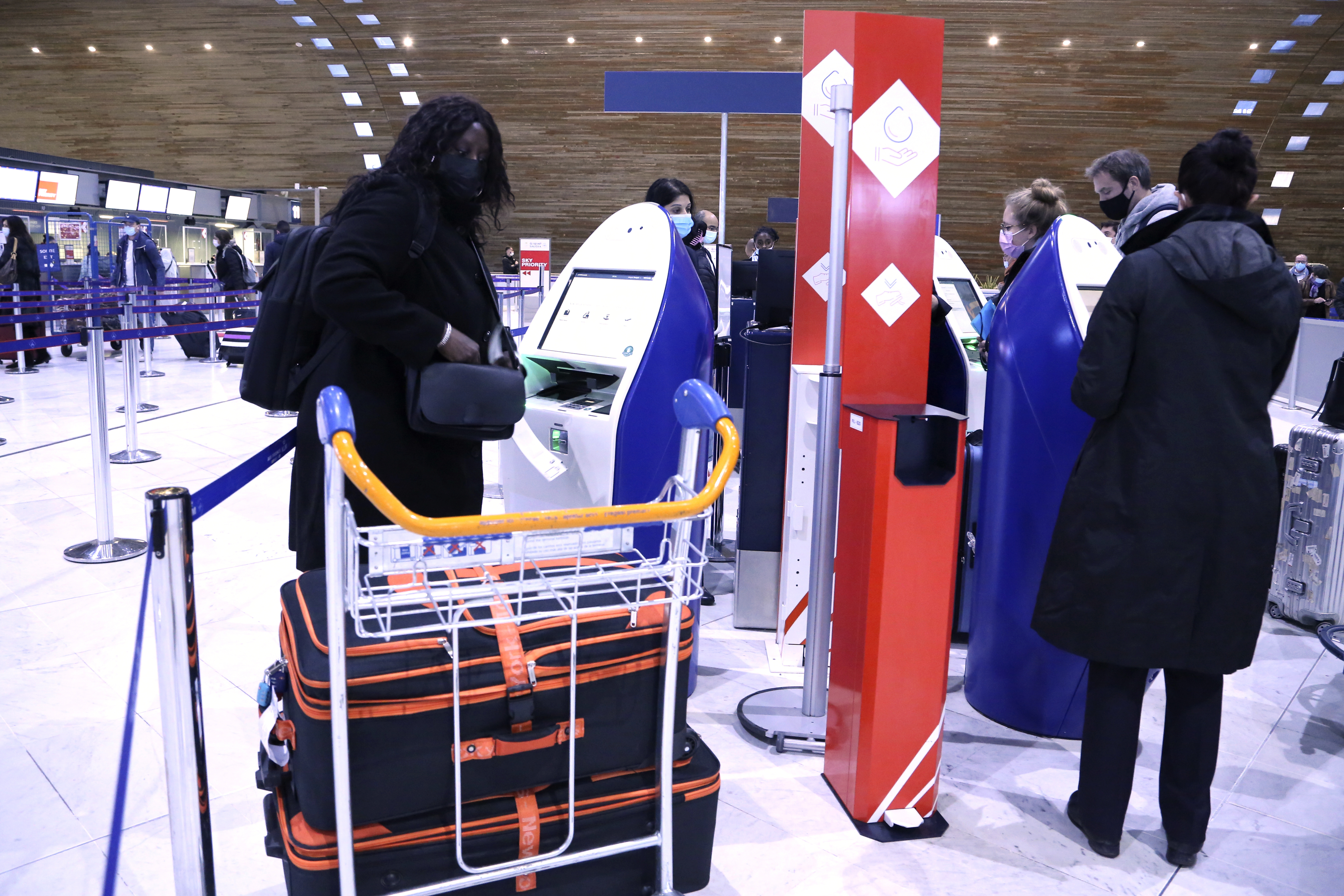 Una mujer se prepara para etiquetar sus maletas en la Terminal 2E del aeropuerto Charles de Gaulle de París para tomar un vuelo a Nueva York el lunes 8 de noviembre de 2021, para reunirse con su esposo. (AP/John Leicester).