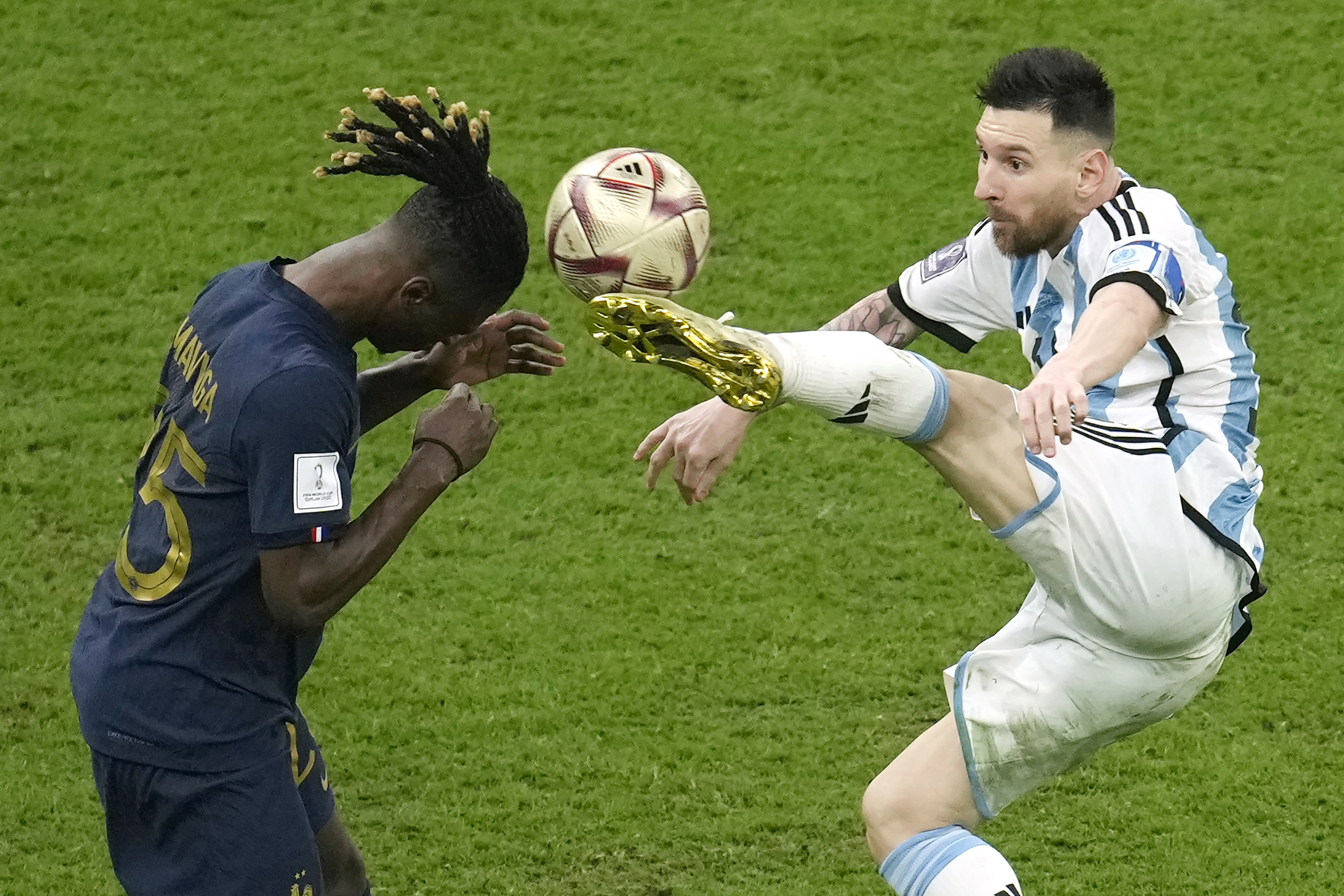 Lionel Messi estira la pierna en busca de la pelota frente a Eduardo Camavigna, en la final mundialista en Lusail, Qatar (AP Foto/Christophe Ena)
