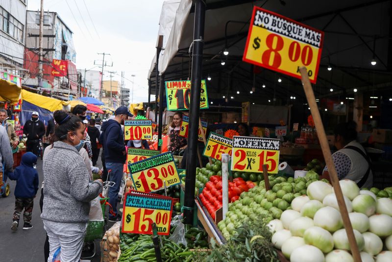 Imagen de archivo. Transeúntes miran carteles con precios de productos afuera de un mercado conocido como La Merced mientras continúa la propagación del coronavirus, en Ciudad de México. 25 de junio de 2020. REUTERS/Henry Romero