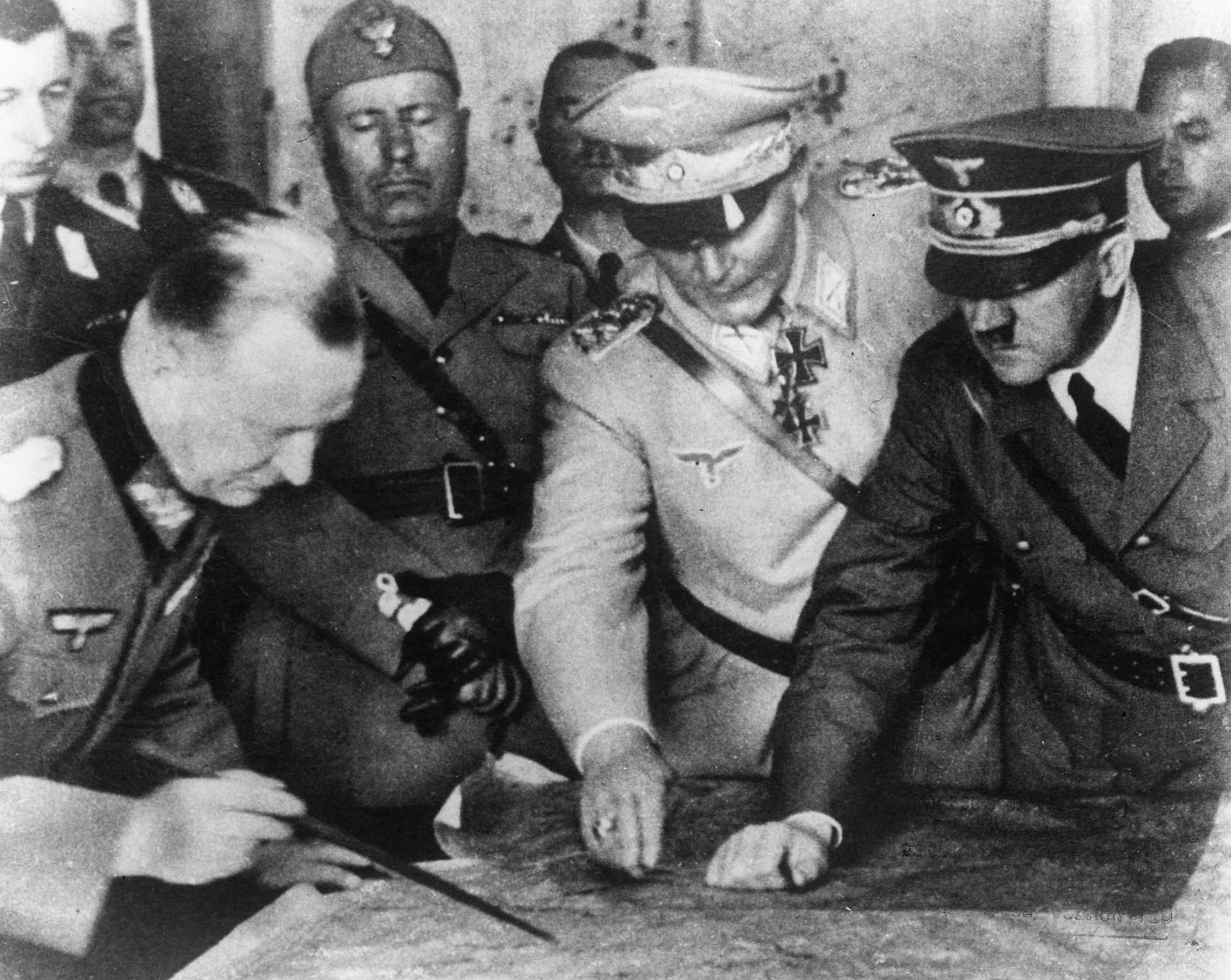 1940: Adolf Hitler, Hermann Goering y otros jerarcas nazis planean una estrategia militar en el cuartel general del ejército alemán. En el fondo está el dictador italiano Benito Mussolini (Keystone/Getty Images)
