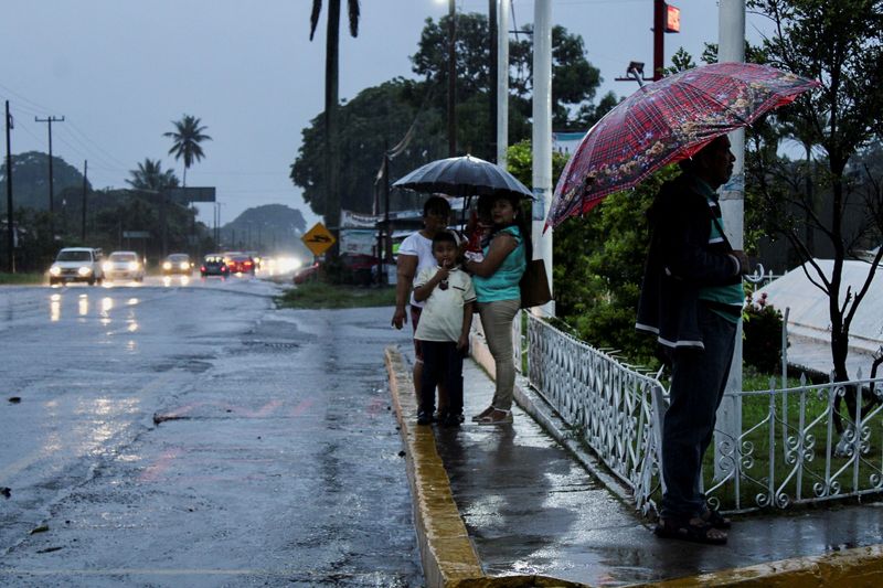 Imagen de archivo. Ciudadanos se protegen de la lluvia bajo los paraguas cuando el huracán Agatha se acerca al sur de México, en Tuxtla Chico, en el estado Chiapas, México. 29 de mayo de 2022. REUTERS/José Torres