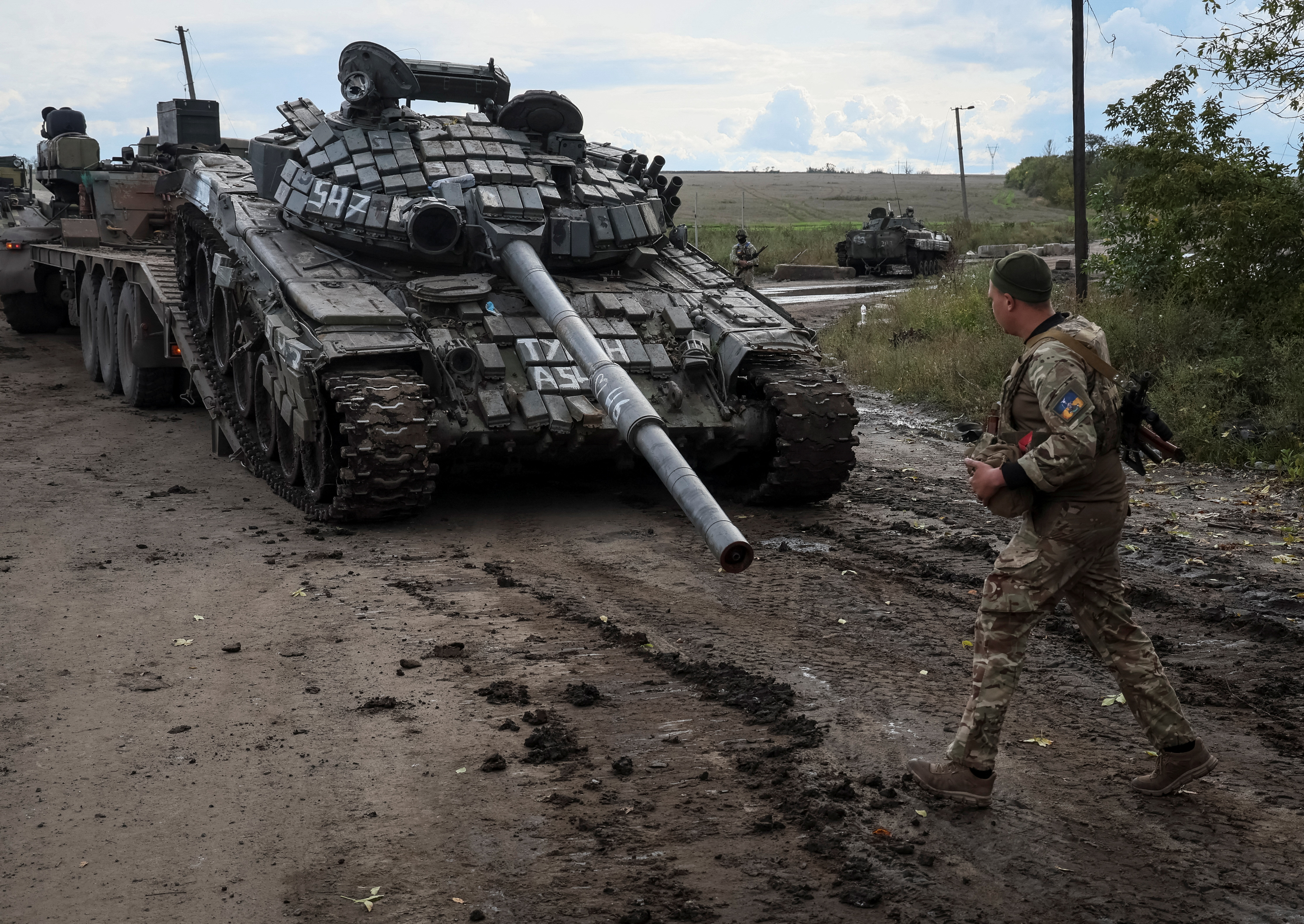 Militares ucranianos cargan un tanque ruso destruido en un camión, mientras continúa el ataque de Rusia a Ucrania, en la ciudad de Izium (Reuters)