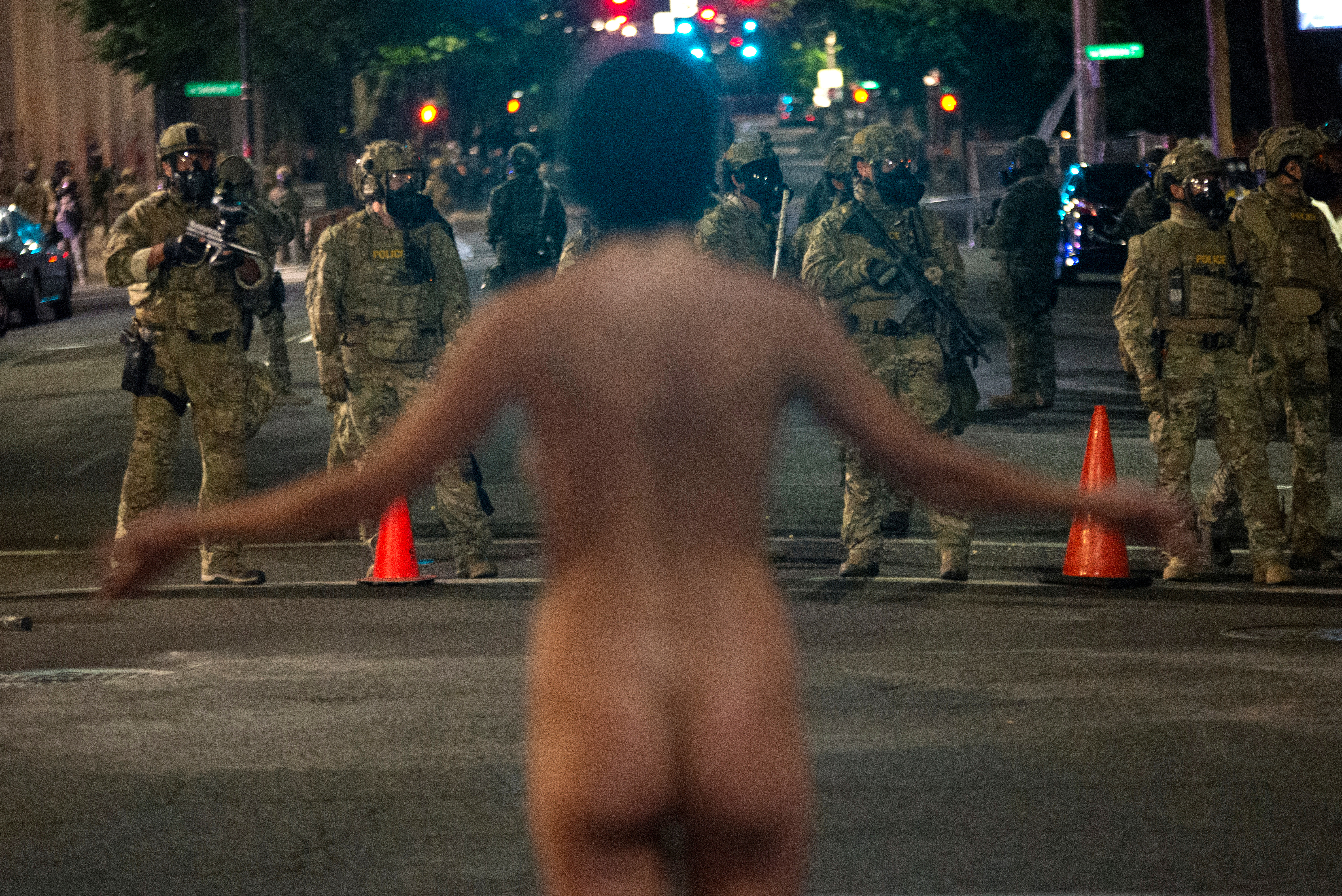 Una manifestante desnuda se enfrenta a los agentes federales, desplegados bajo la nueva orden ejecutiva de la administración Trump para proteger los monumentos y edificios federales (REUTERS/Nathan Howard)