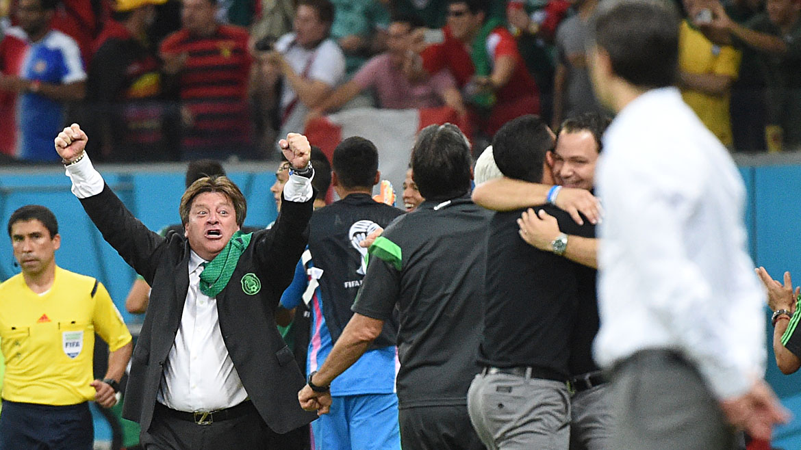 Mexico's coach Miguel Herrera (2nd L) celebrates after his team won a Group A football match between Croatia and Mexico at the Pernambuco Arena in Recife during the 2014 FIFA World Cup on June 23, 2014. Mexico won 3-1.   AFP PHOTO / DIMITAR DILKOFF
