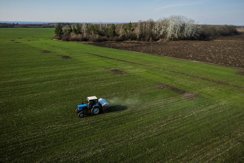 FOTO DE ARCHIVO: Una vista aérea muestra un tractor esparciendo fertilizante en un campo de trigo cerca de la aldea de Yakovlivka después de haber sido alcanzada por un bombardeo aéreo en las afueras de Járkov, mientras continúa el ataque de Rusia a Ucrania, 5 de abril de 2022. REUTERS/Thomas Peter