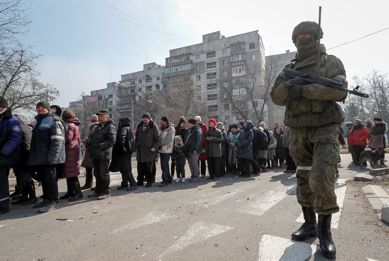 Locals line up for humanitarian aid in the besieged southern port of Mariupol