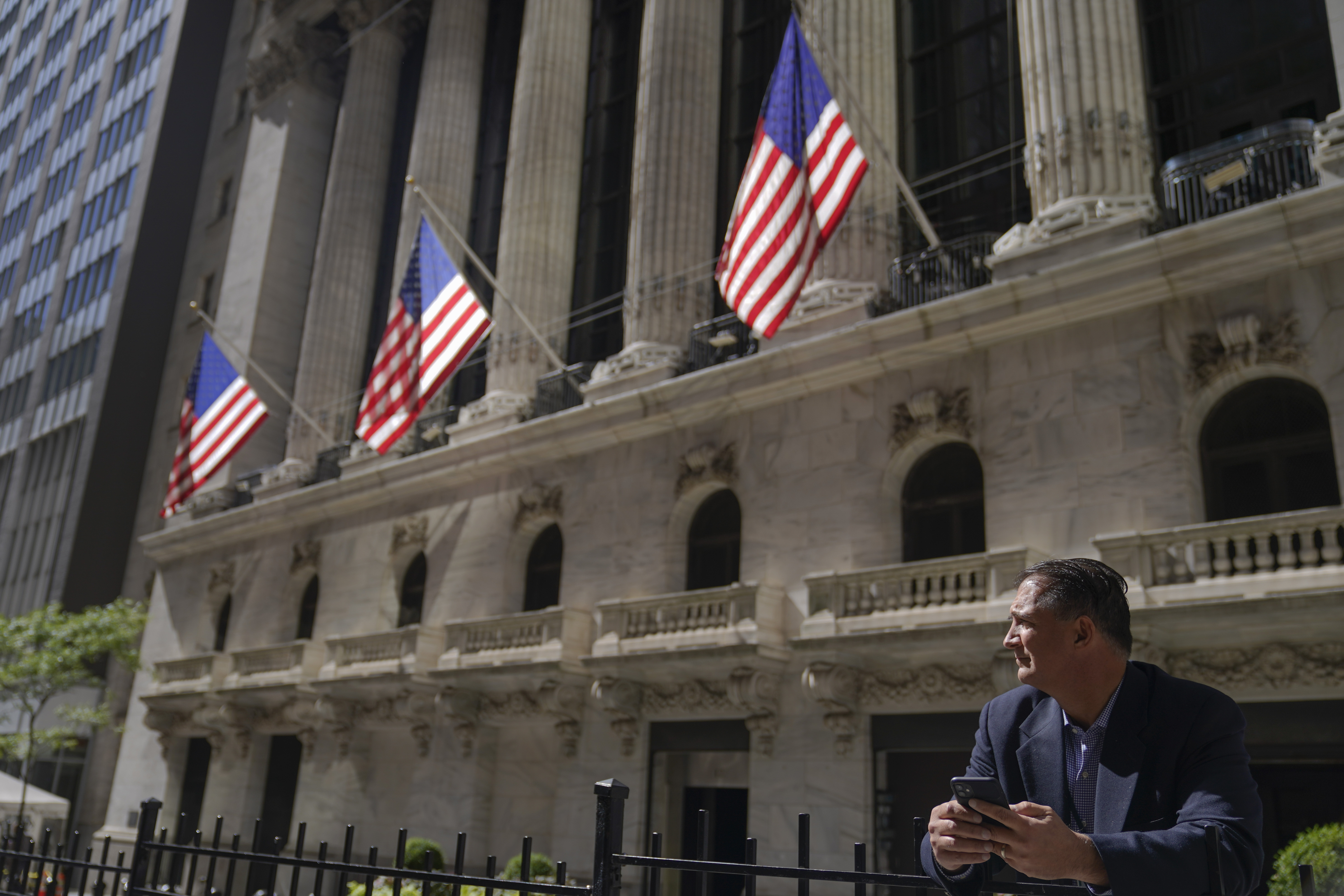 A man uses his cell phone outside the New York Stock Exchange.  (AP Photo/Mary Altaffer)