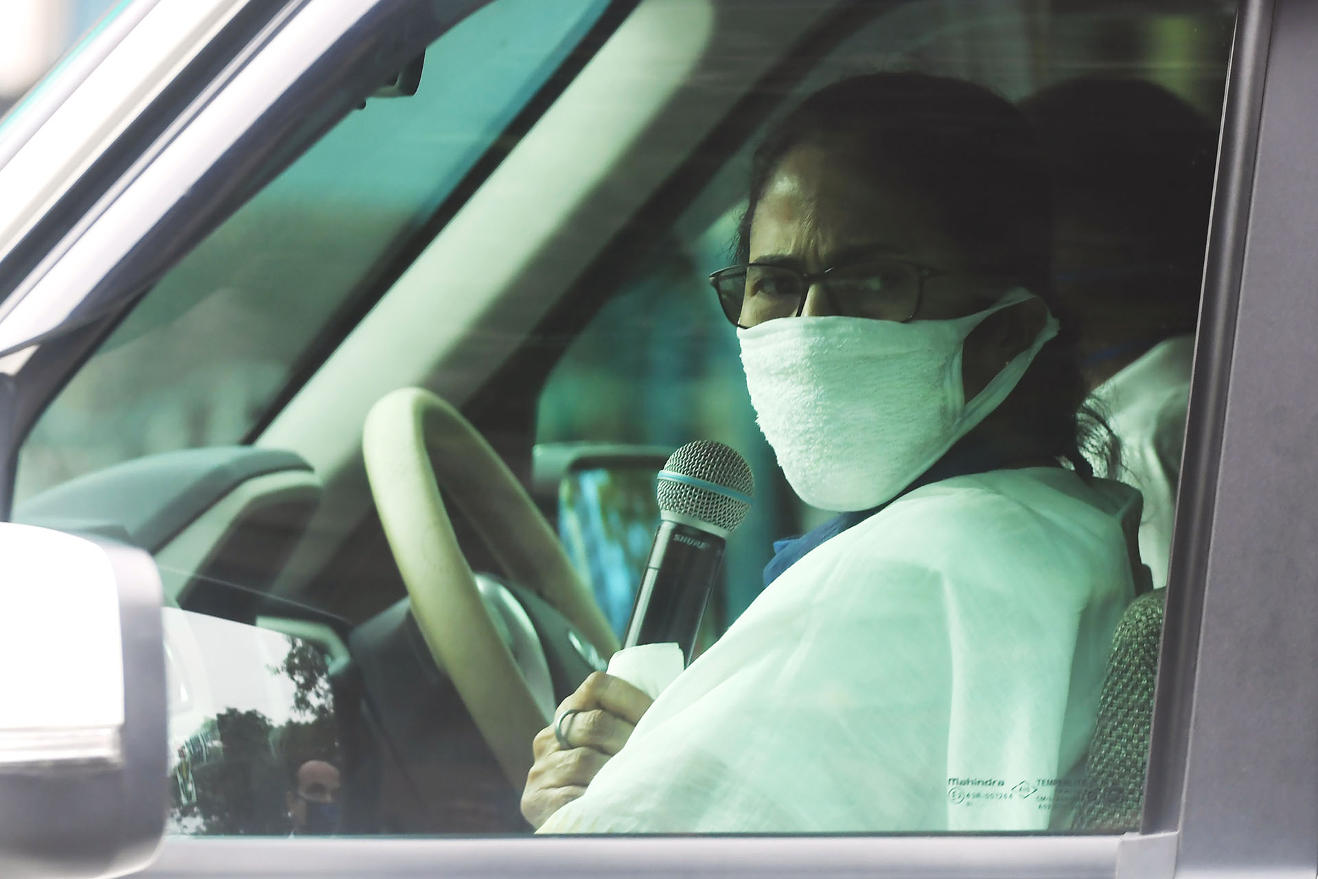 La Ministra Principal de Bengala Occidental, Mamata Banerjee, saluda con la mano mientras pronuncia un discurso desde su coche durante la cuarentena en Calcuta el 23 de abril de 2020. (Foto de Dibyangshu SARKAR / AFP)
