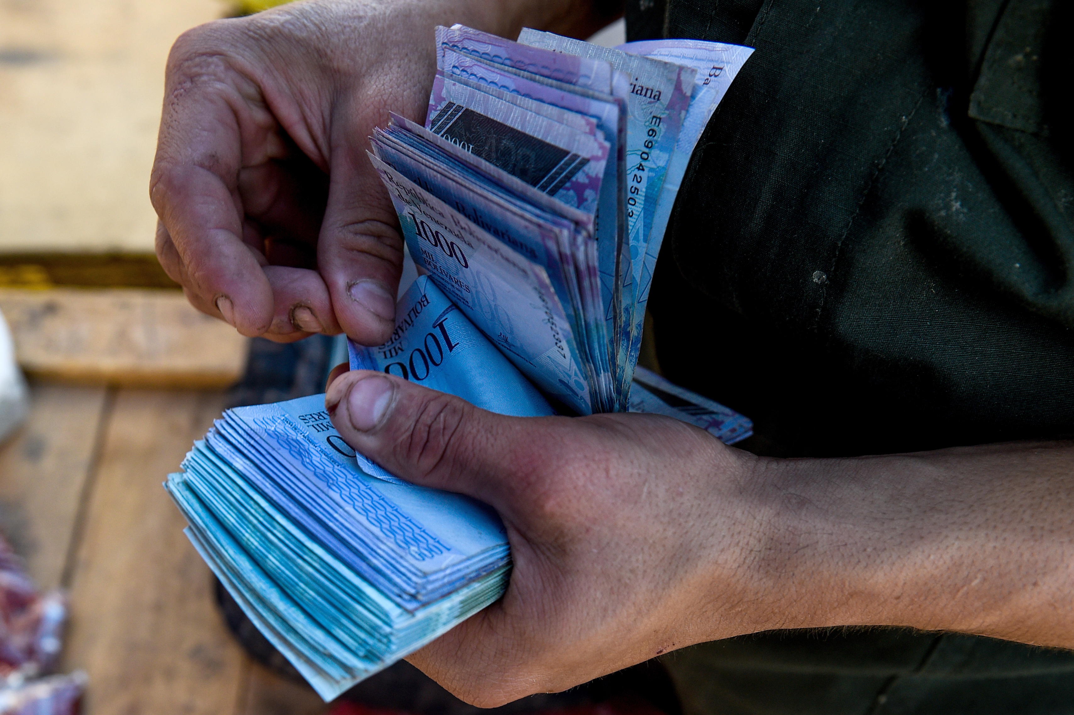 Foto de un fajo de bolívares, cuyo valor continúa decreciendo a medida que continúa la hiperinflación en Venezuela. Foto: AFP/ Federico PARRA