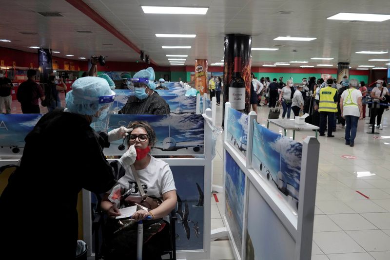 Un trabajador de la salud toma una muestra a una turista que viene de México a su llegada al Aeropuerto Internacional José Martí, en La Habana, Cuba (Foto: REUTERS/Alexandre Meneghini)