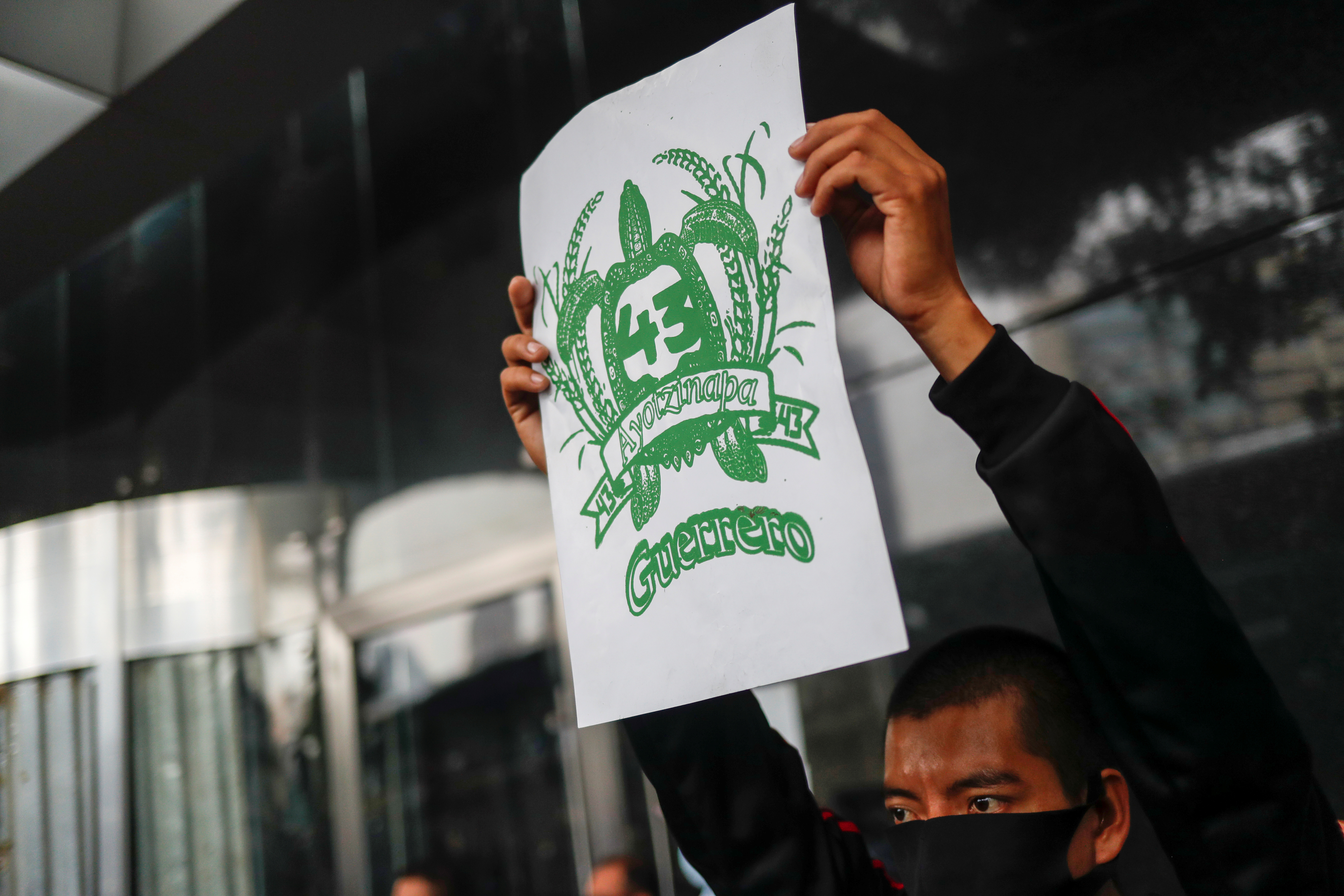 Un estudiante de la EEscuela Normal Rural de Ayotzinapa sostiene un cartel durante una protesta frente a la Fiscalía General, antes del sexto aniversario de la desaparición de 43 estudiantes, en la Ciudad de México, México, 25 de septiembre de 2020.