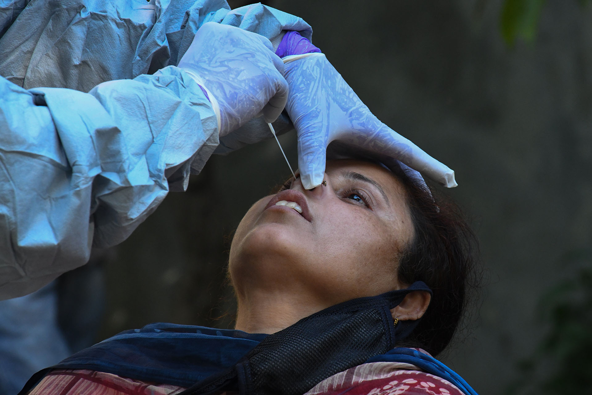 Un médico toma una muestra de una mujer para una prueba de COVID-19 en Amritsar el 23 de abril de 2020, durante la cuarentena nacional impuesta por el gobierno como medida preventiva contra el coronavirus (Foto de NARINDER NANU / AFP)