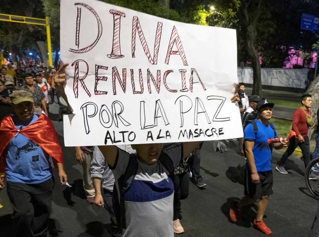 Manifestante antigubernamental eleva un cartel que pide la renuncia de Dina Boluarte. Foto: AFP