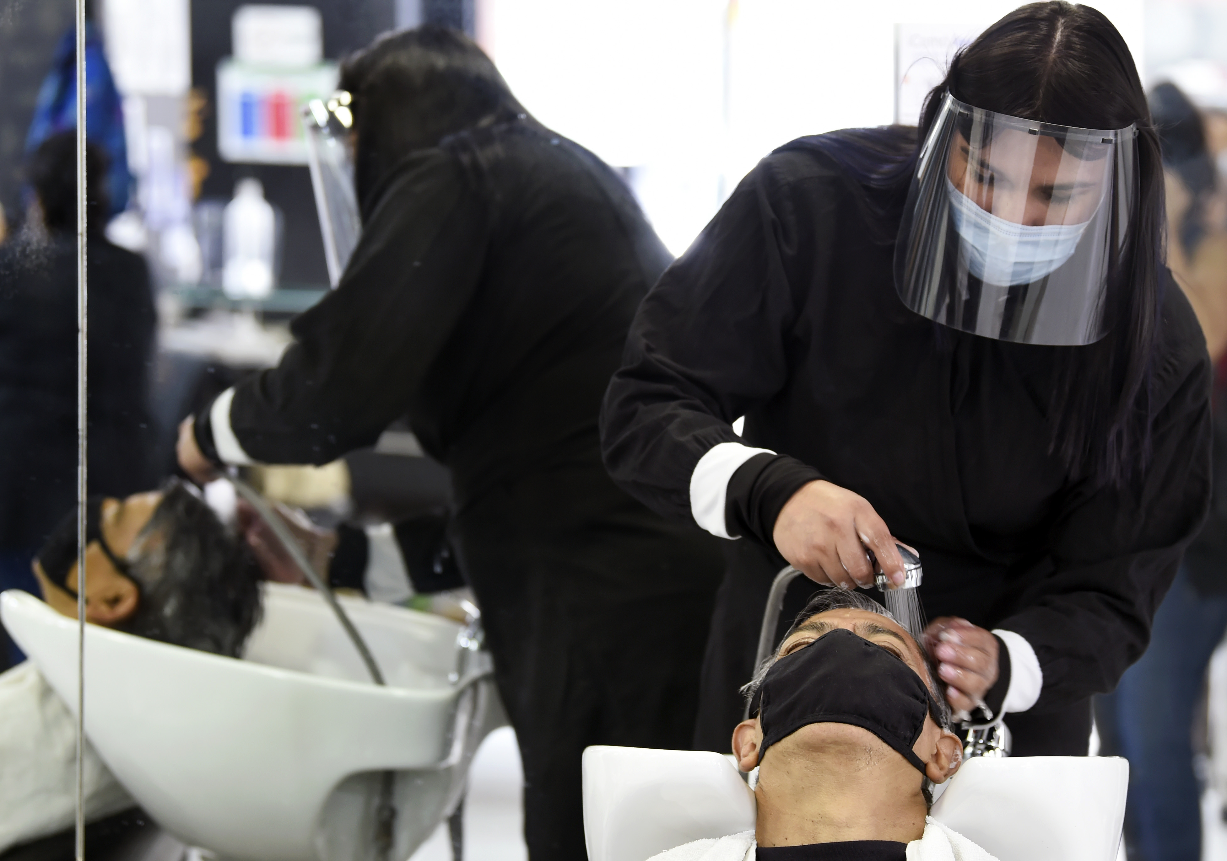 Un empleado en un salón de belleza atiende a un cliente, durante la pandemia COVID-19, en la Ciudad de México el 29 de junio de 2020. (Foto: ALFREDO ESTRELLA / AFP)