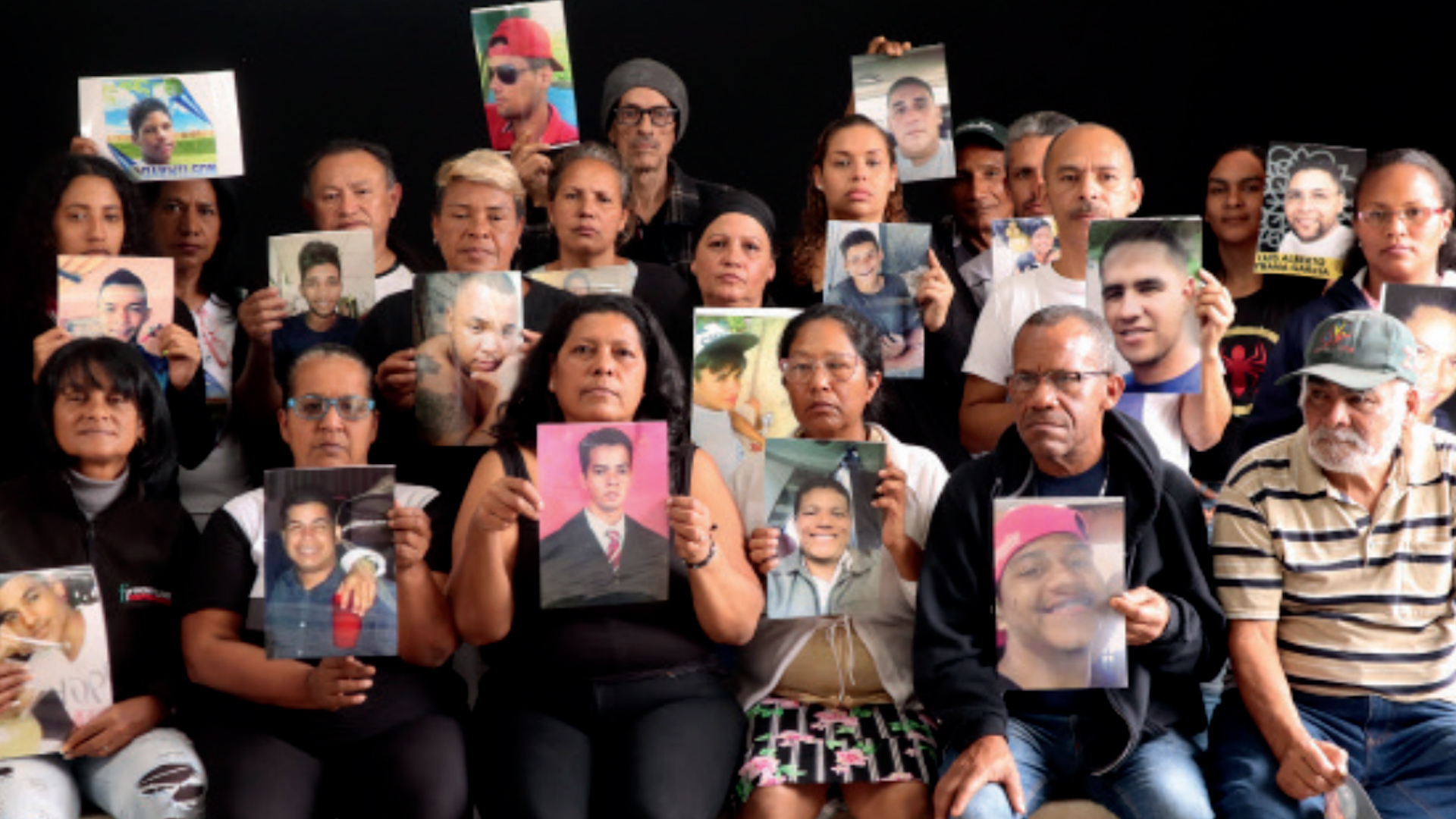Personas muestran fotografías de familiares asesinados por las fuerzas policiales o militares de Venezuela (Lupa por la Vida)