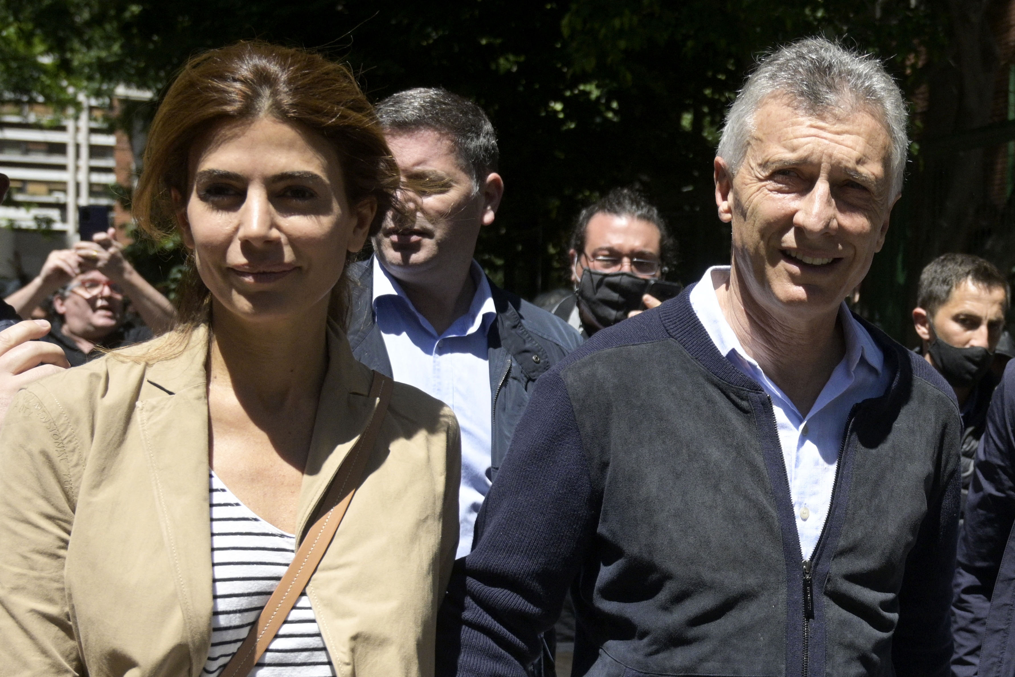 Argentina's former President Mauricio Macri (R), accompanied by his wife Juliana Awada (L), leaves the polling station after casting his vote during the mid-term parliamentary elections in Buenos Aires, on November 14, 2021. - Argentines head to the polls in mid-term parliamentary elections on Sunday that could see President Alberto Fernandez' party lose its Senate majority. (Photo by JUAN MABROMATA / AFP)