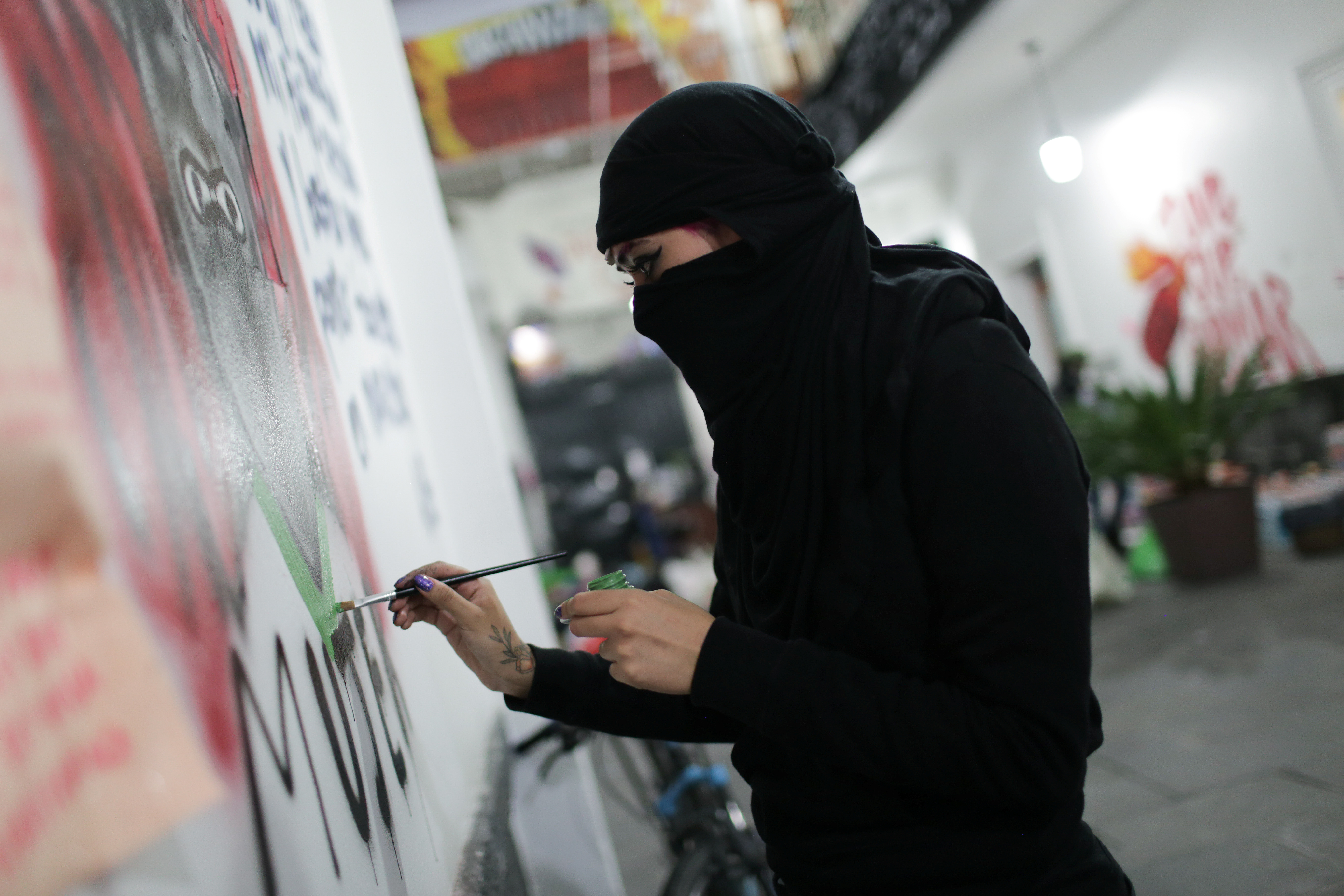 Una integrante de un colectivo feminista pinta un graffiti dentro de las instalaciones del edificio de la Comisión Nacional de Derechos Humanos, en apoyo a las víctimas de violencia de género, en la Ciudad de México, México, 10 de septiembre de 2020. Fotografía tomada el 10 de septiembre de 2020.