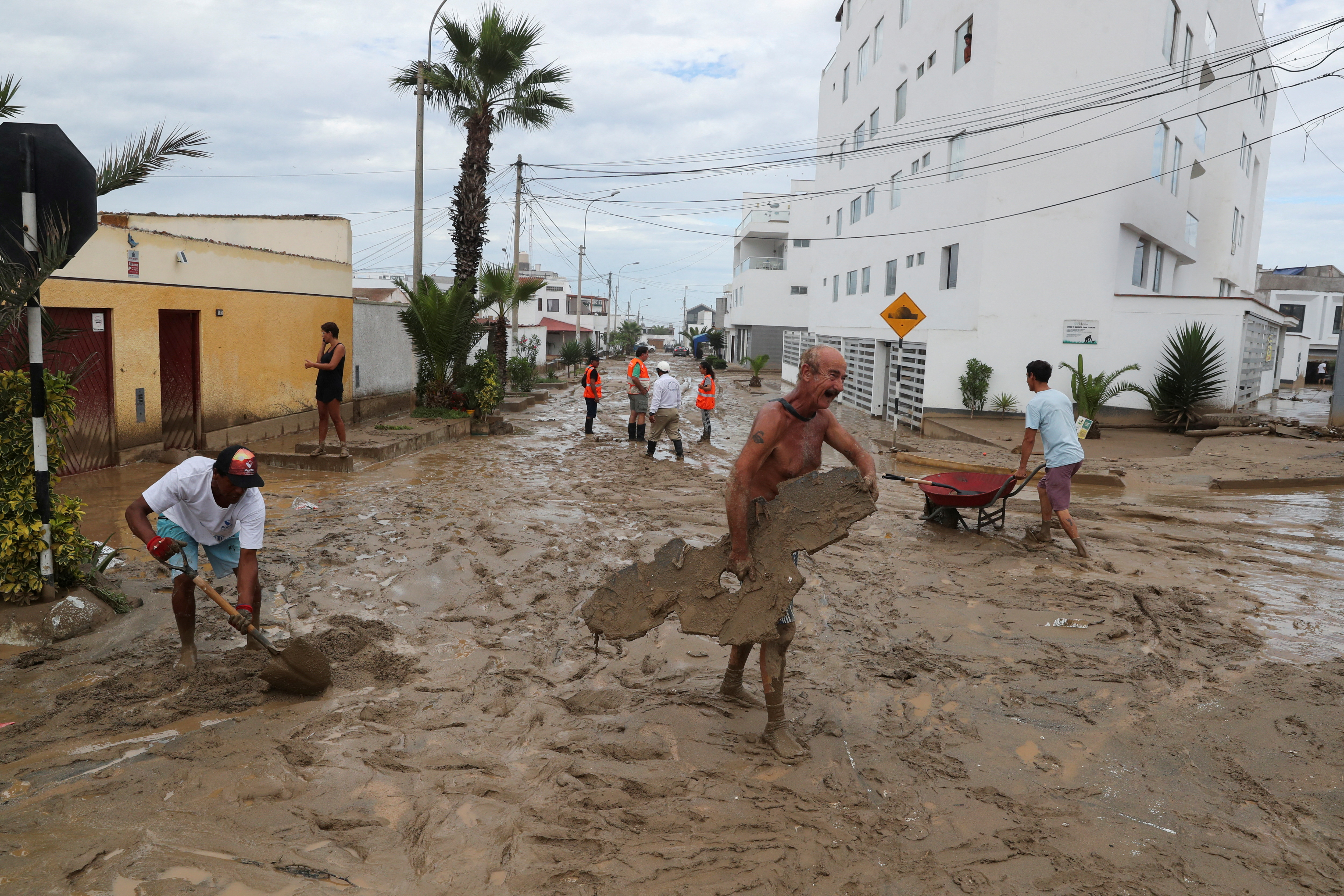 People work to remove mud following Cyclone Yaku in Punta Hermosa, Peru, March 15, 2023. REUTERS/Sebastian Castaneda