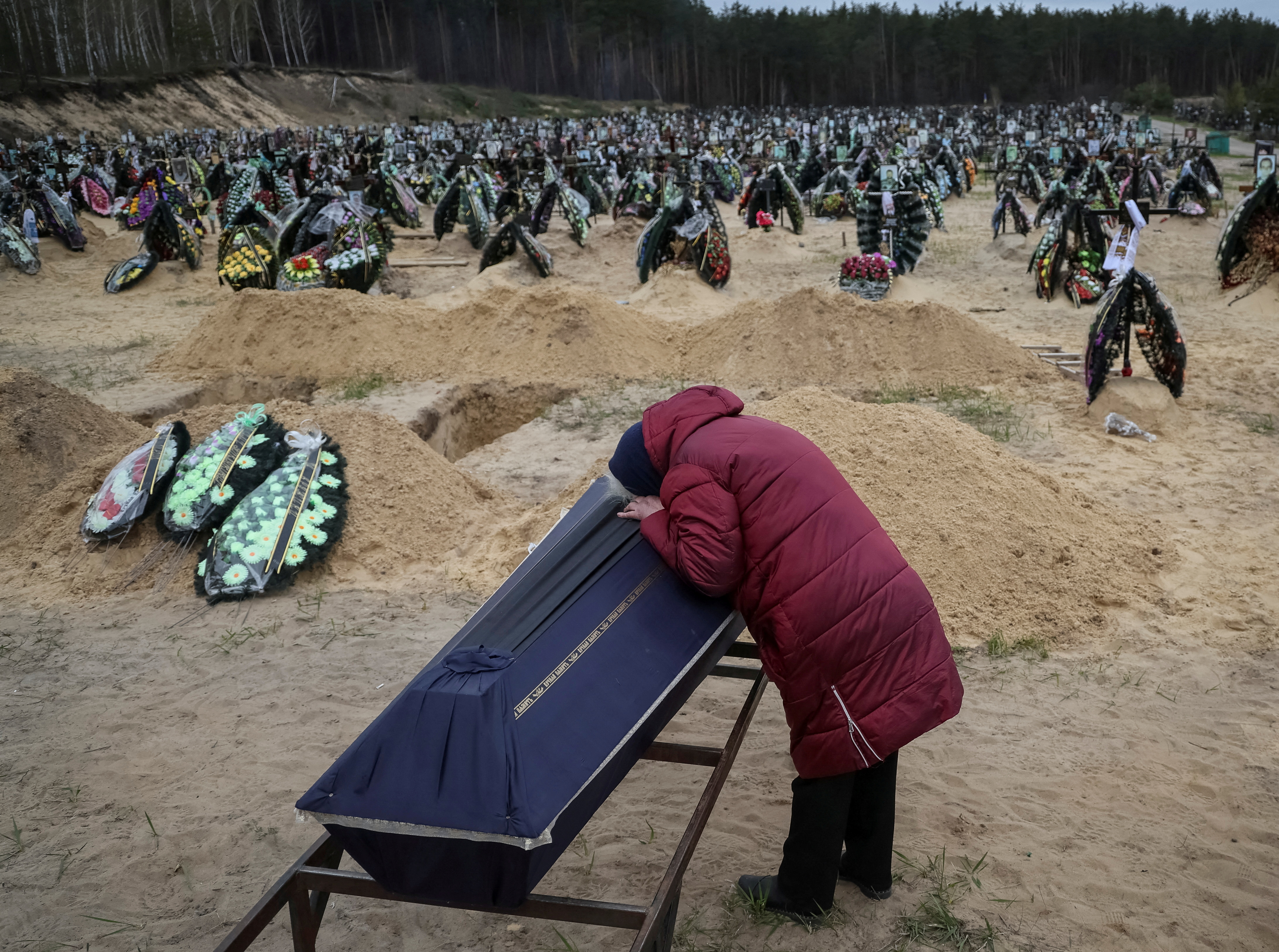 Una mujer reacciona durante el funeral de su pariente, que murió durante el bombardeo de las tropas rusas, en medio de la invasión rusa de Ucrania, en el cementerio de Irpin, región de Kiev, Ucrania (REUTERS/Gleb Garanich)