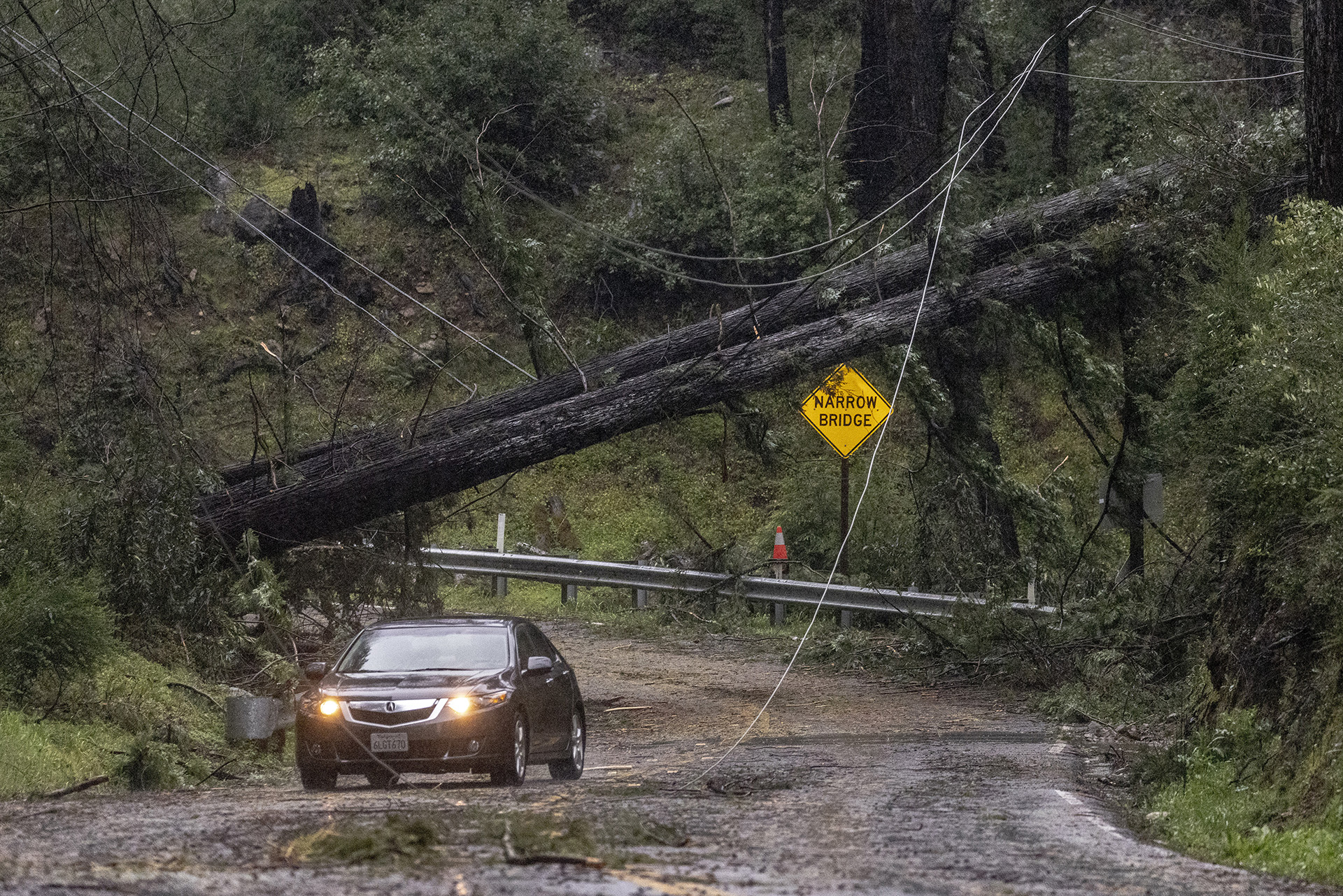Un vehículo pasa junto a árboles caídos a lo largo de Big Basin Way durante la última tormenta atmosférica en Boulder Creek, California, el martes 21 de marzo de 2023. (Stephen Lam/San Francisco Chronicle vía AP)

