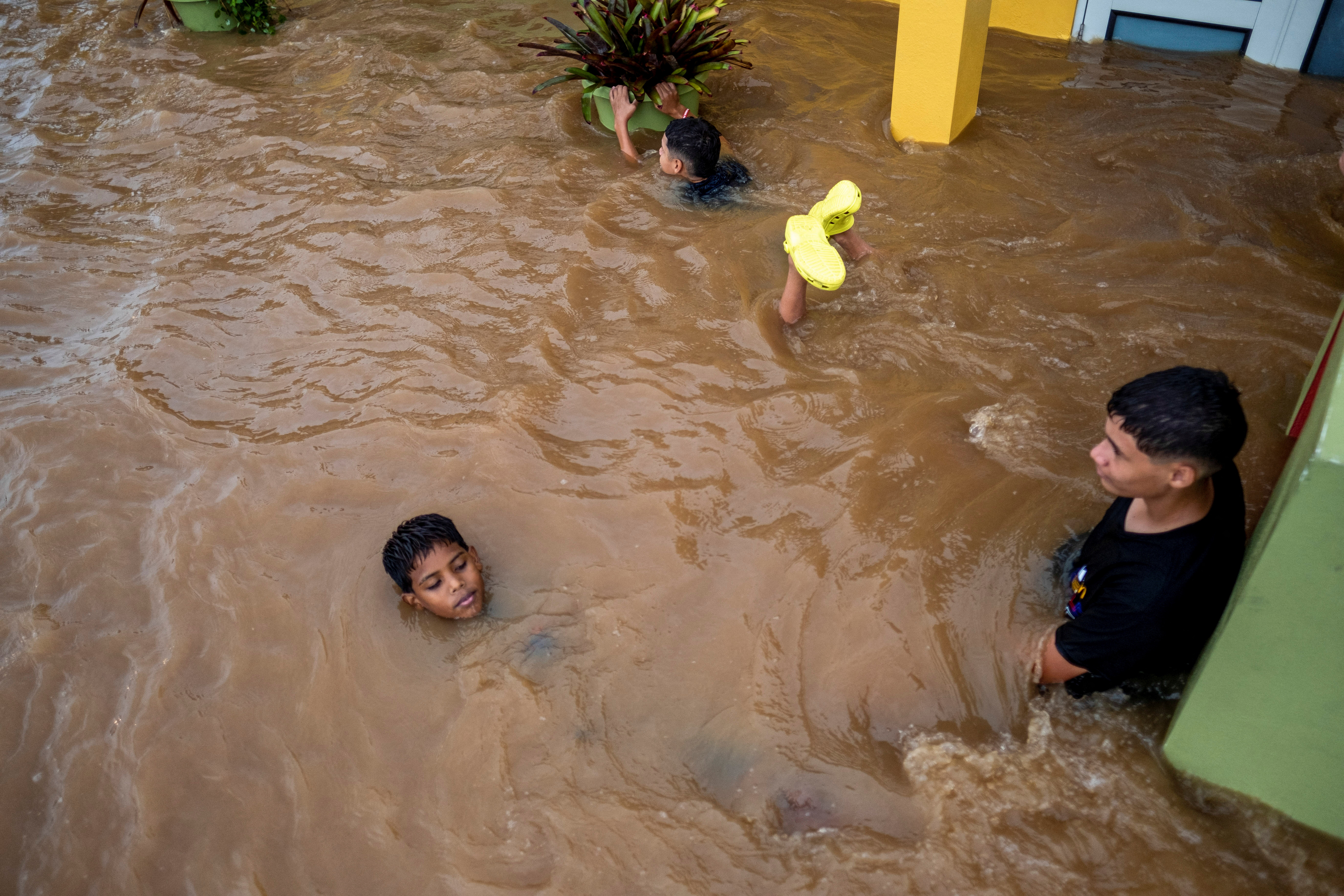 Niños juegan en una calle inundada después del huracán Fiona en Salinas, Puerto Rico 19 de septiembre de 2022. REUTERS/Ricardo Arduengo