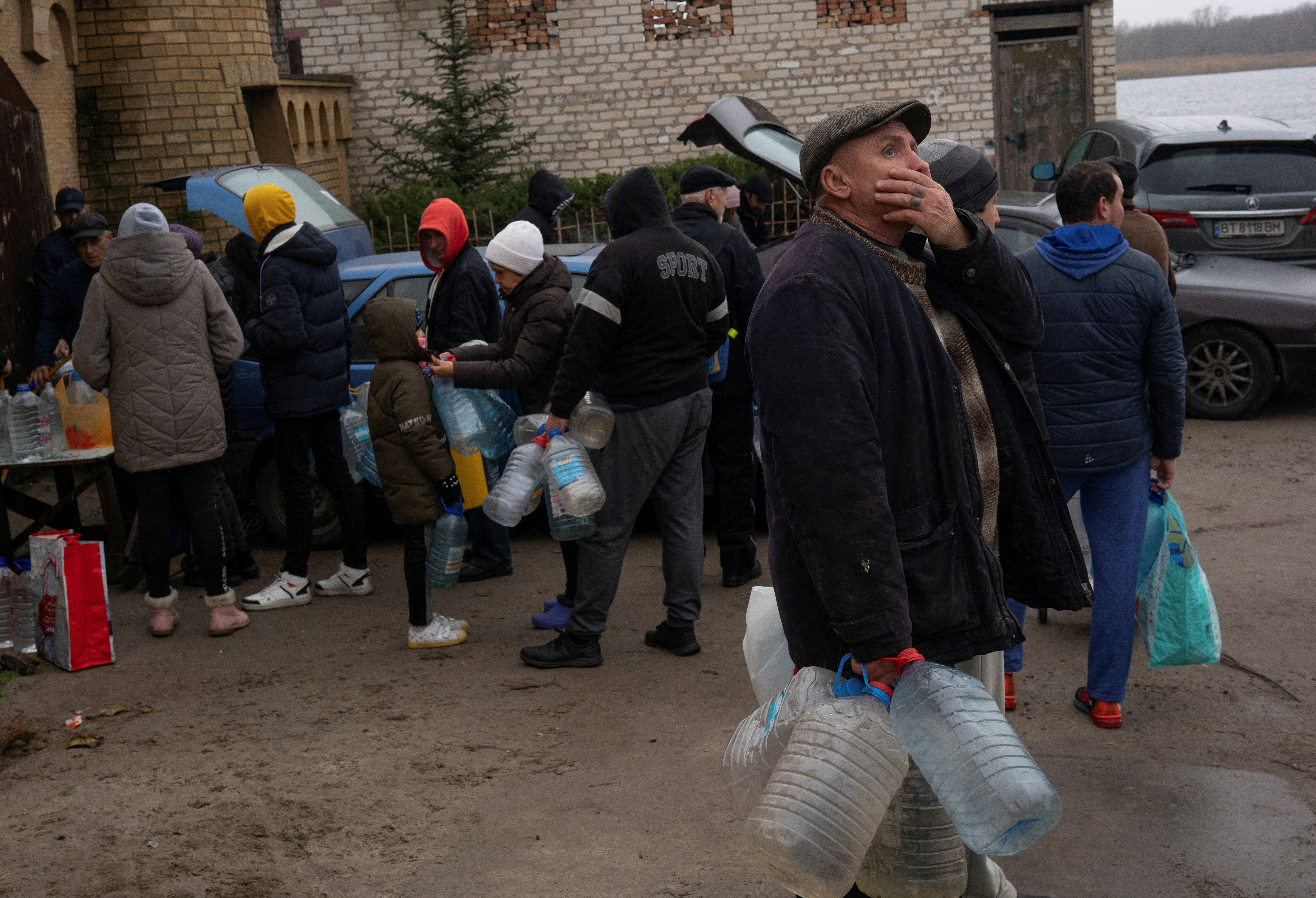Colas para conseguir agua potable en la ciudad reconquistada de Kherson que estuvo durante ocho meses en manos de los rusos. (REUTERS/Anna Voitenko)     