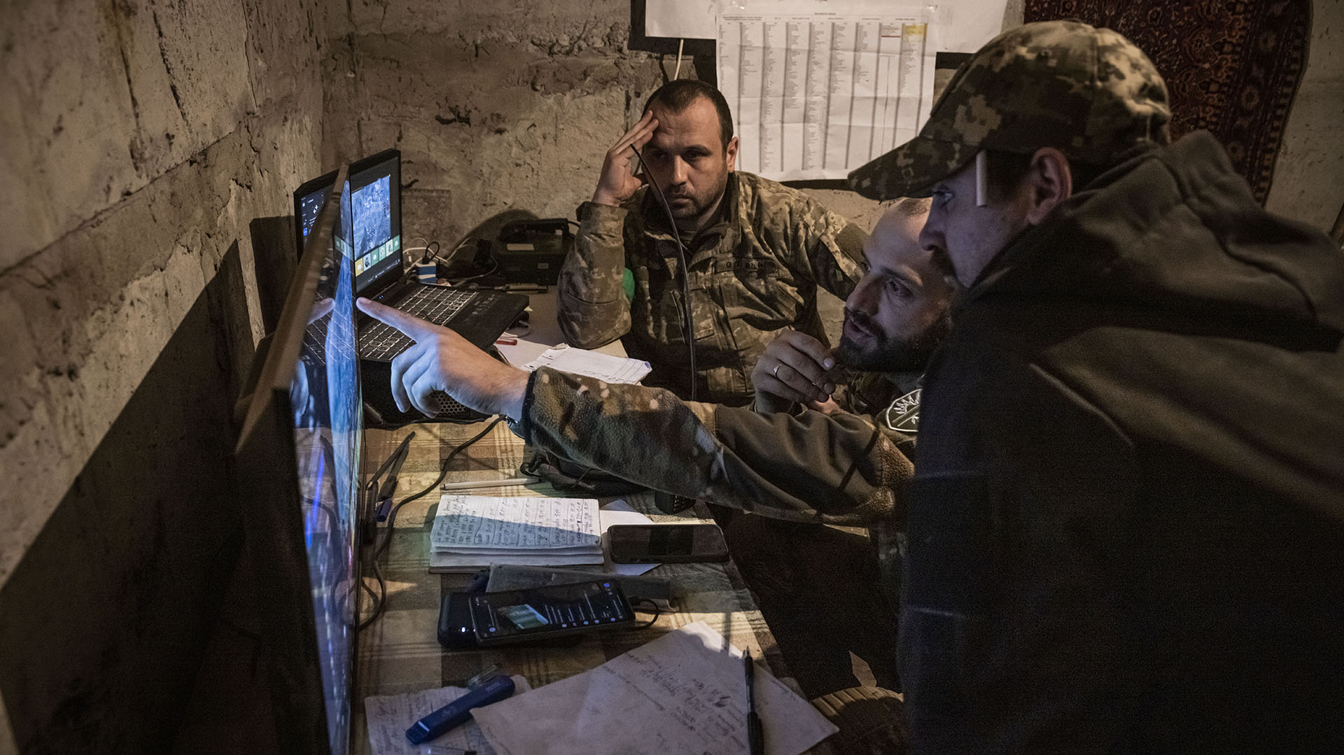Soldados de la 77ª brigada ucraniana observan el movimiento de soldados rusos en las imágenes de vídeo en directo de los drones que planean sobre Bakhmut en una base subterránea en Chasiv Yar el viernes (Foto para The Washington Post de Ed Ram)