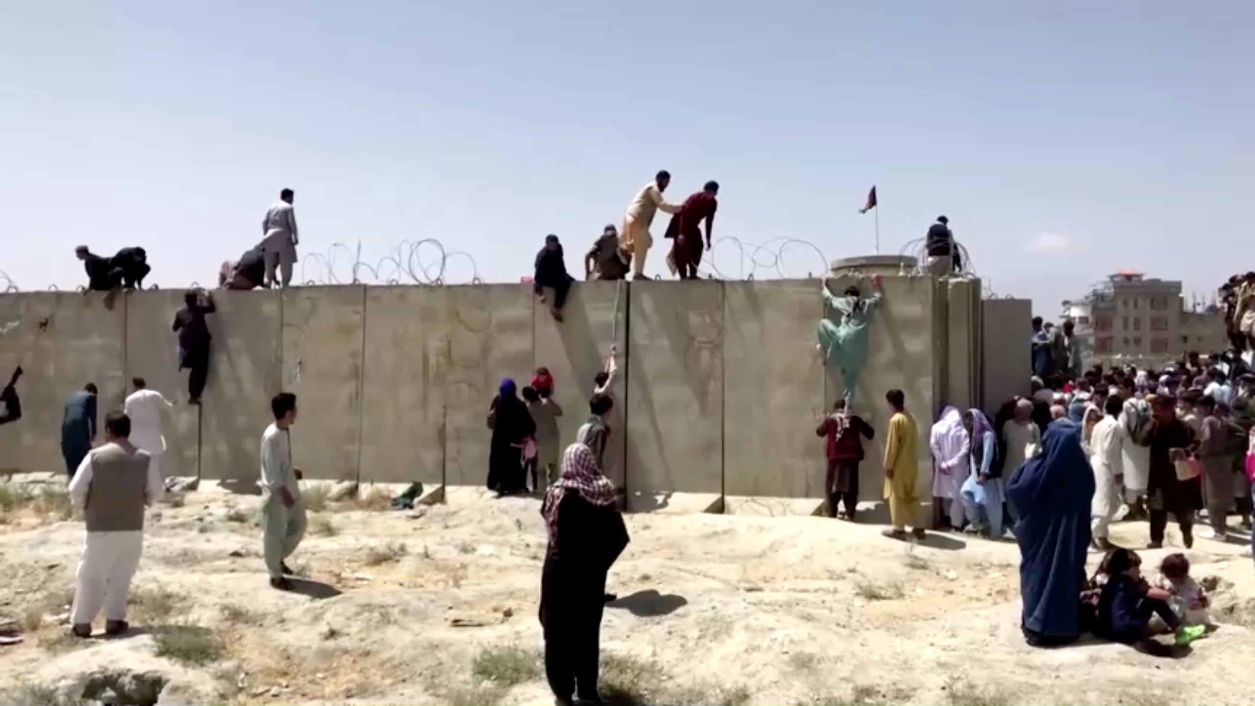 La desesperación de los afganois que trepan un muro en el principal aeropuerto del país REUTERS TV/via REUTERS