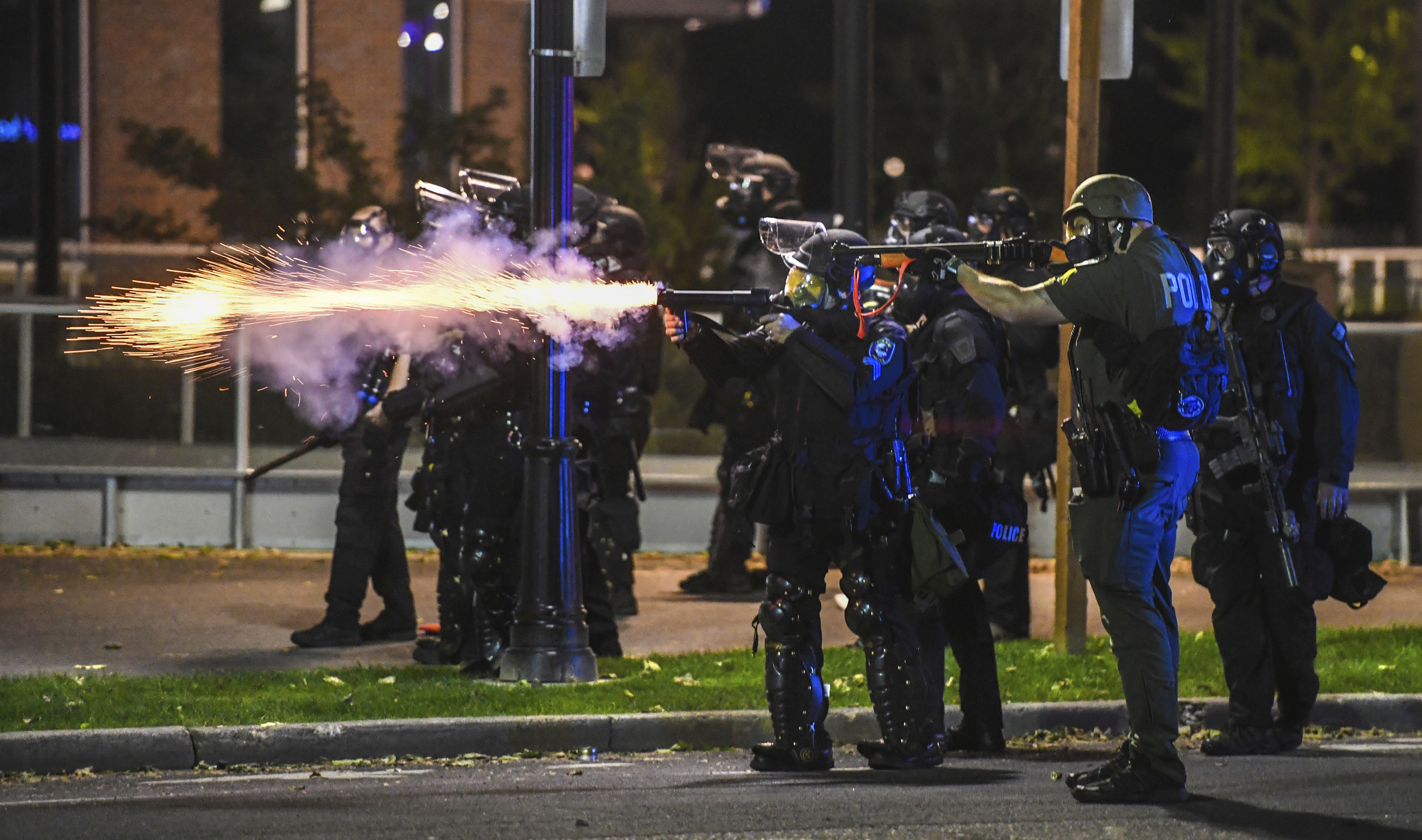Policías disparan a los manifestantes en Spokane, en el estado de Washington, durante las protestas de este domingo. (Dan Pelle/The Spokesman-Review via AP)