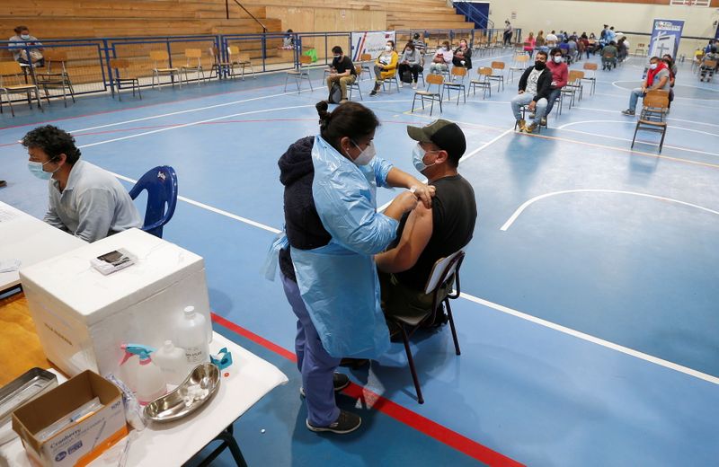 Un hombre recibe una dosis de la vacuna contra el COVID-19 de Pfizer/BioNTech en un gimnasio en medio del brote de coronavirus, en Villa Alemana, Chile (REUTERS/Rodrigo Garrido)