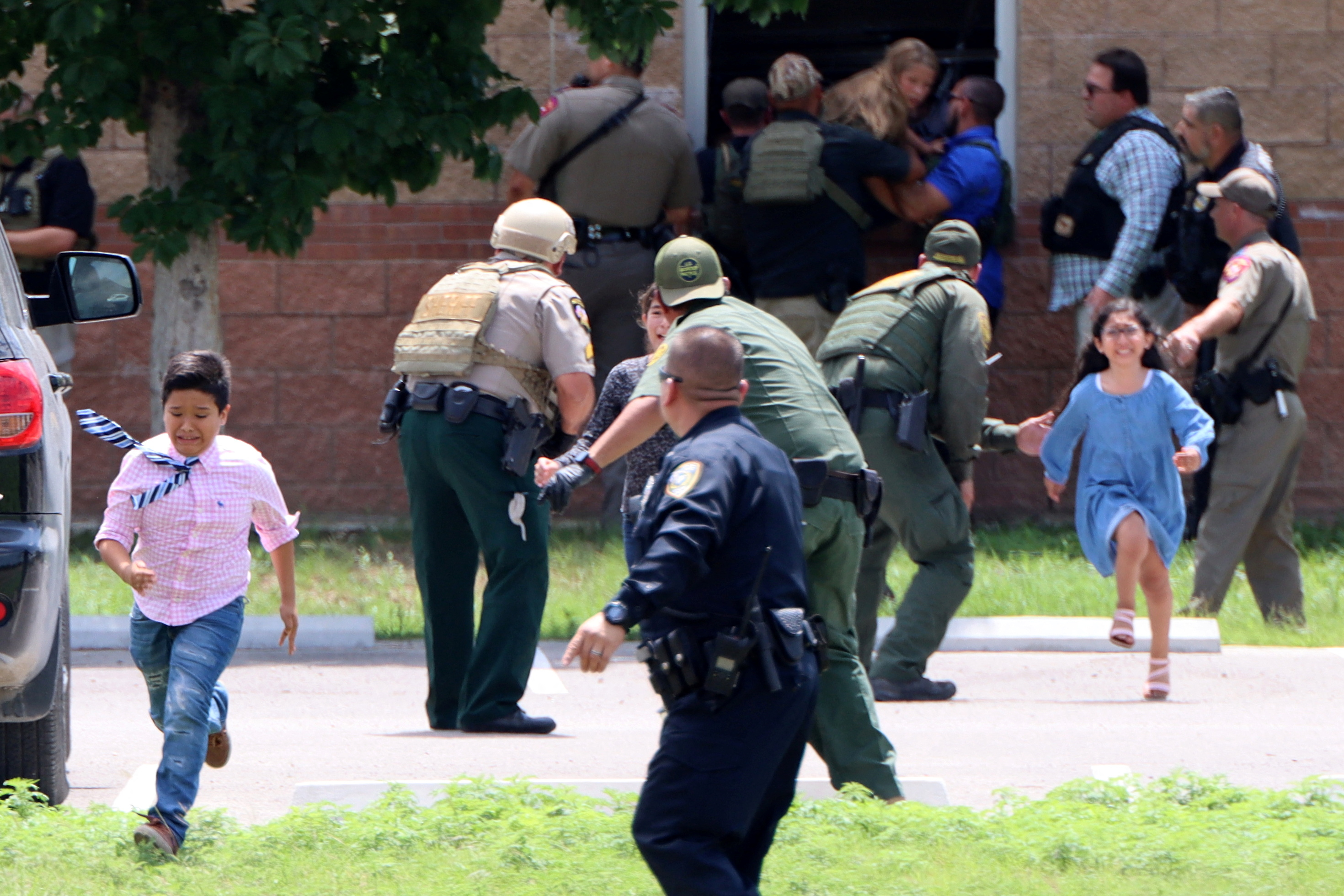 Children run to safety after escaping from a window during a mass shooting at Robb Elementary School where a gunman killed nineteen children and two adults in Uvalde, Texas, U.S. May 24, 2022. Picture taken May 24, 2022.  Pete Luna/Uvalde Leader-News/Handout via REUTERS  NO RESALES. NO ARCHIVES. MANDATORY CREDIT