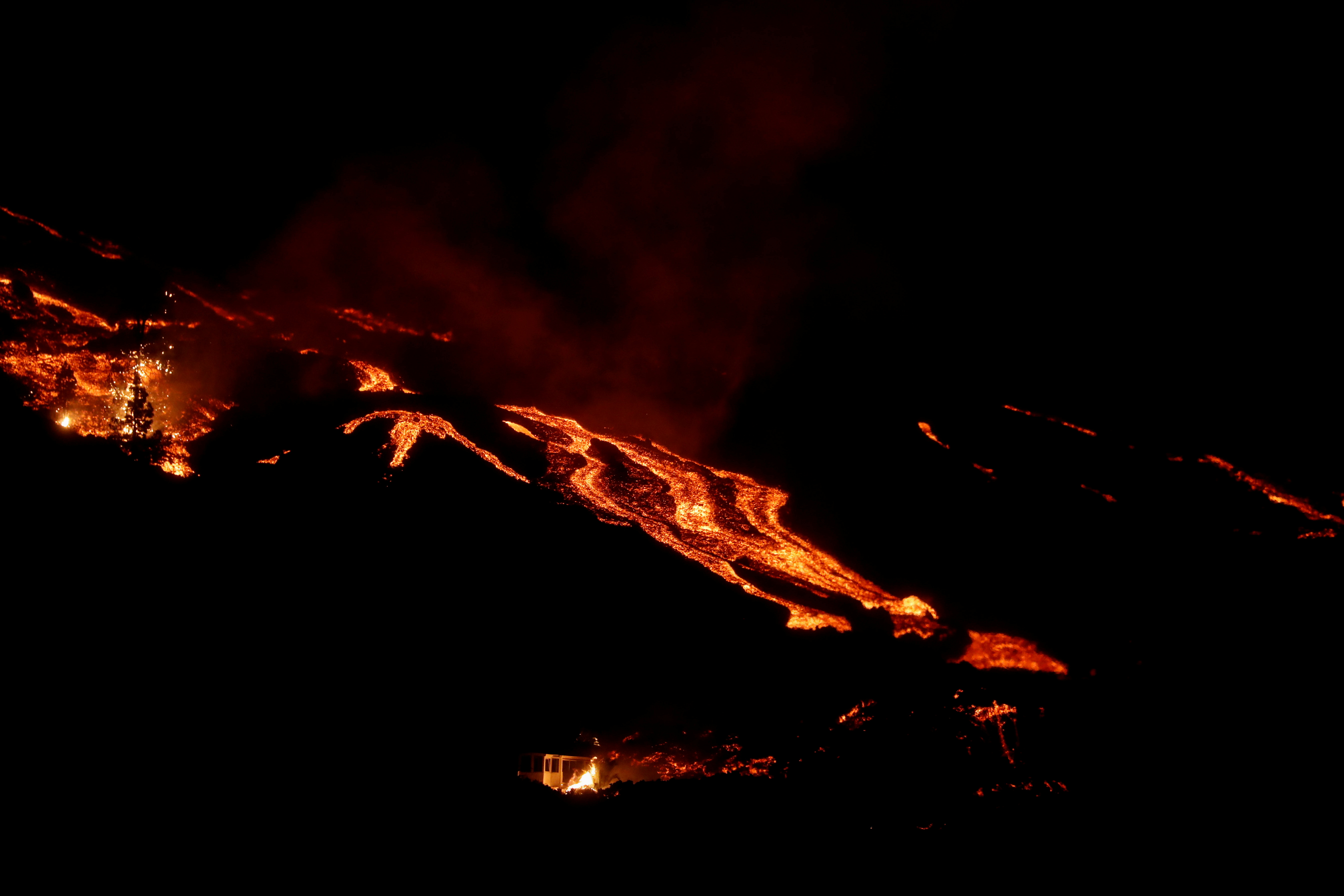 La lava del volcán fluye cuesta abajo junto a una casa en llamas (REUTERS/Susana Vera)