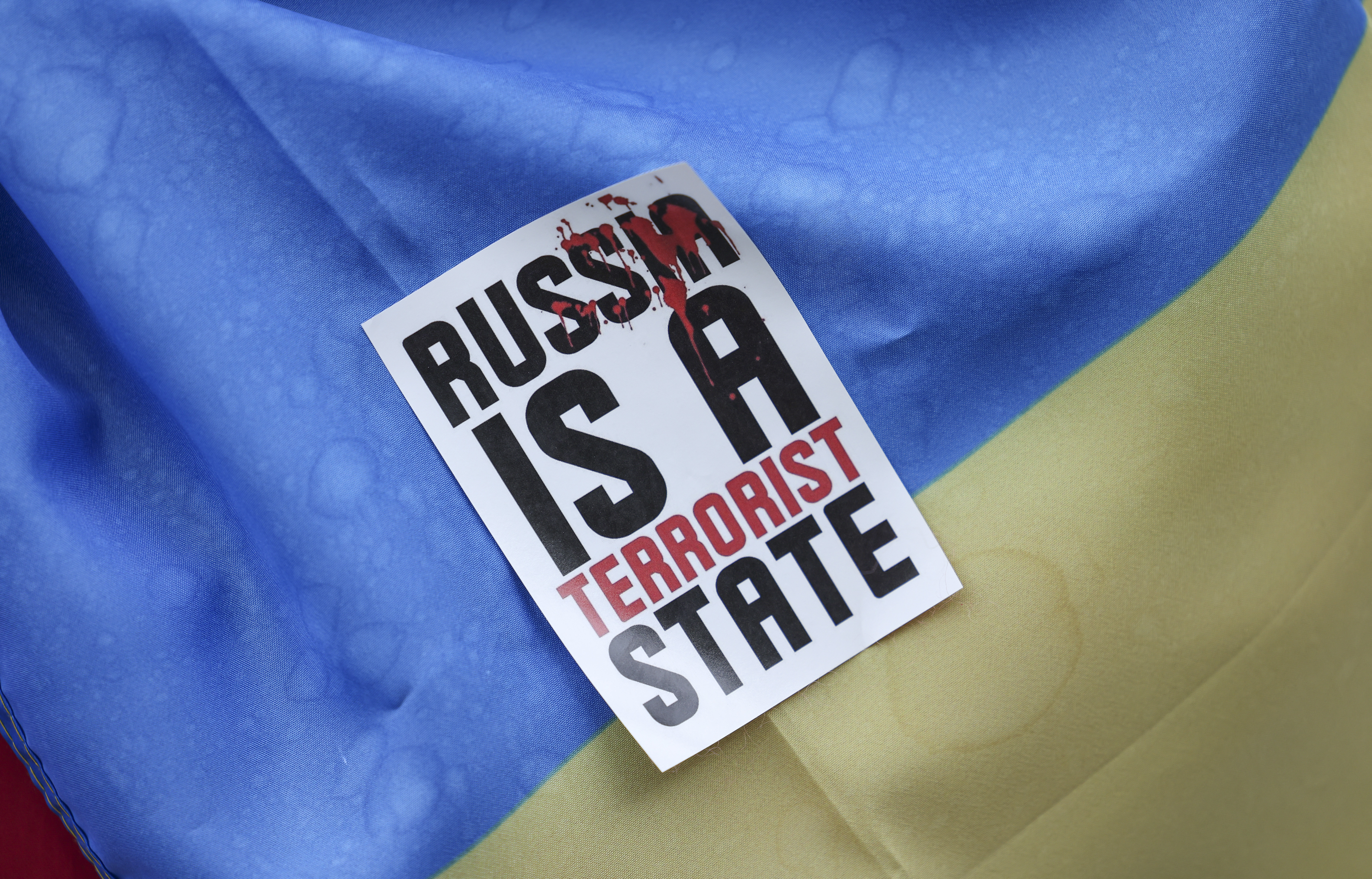 Un cartel que dice "Rusia es un estado terrorista" junto a una bandera ucraniana durante una protesta en Francfurt (REUTERS/Alex Kraus)