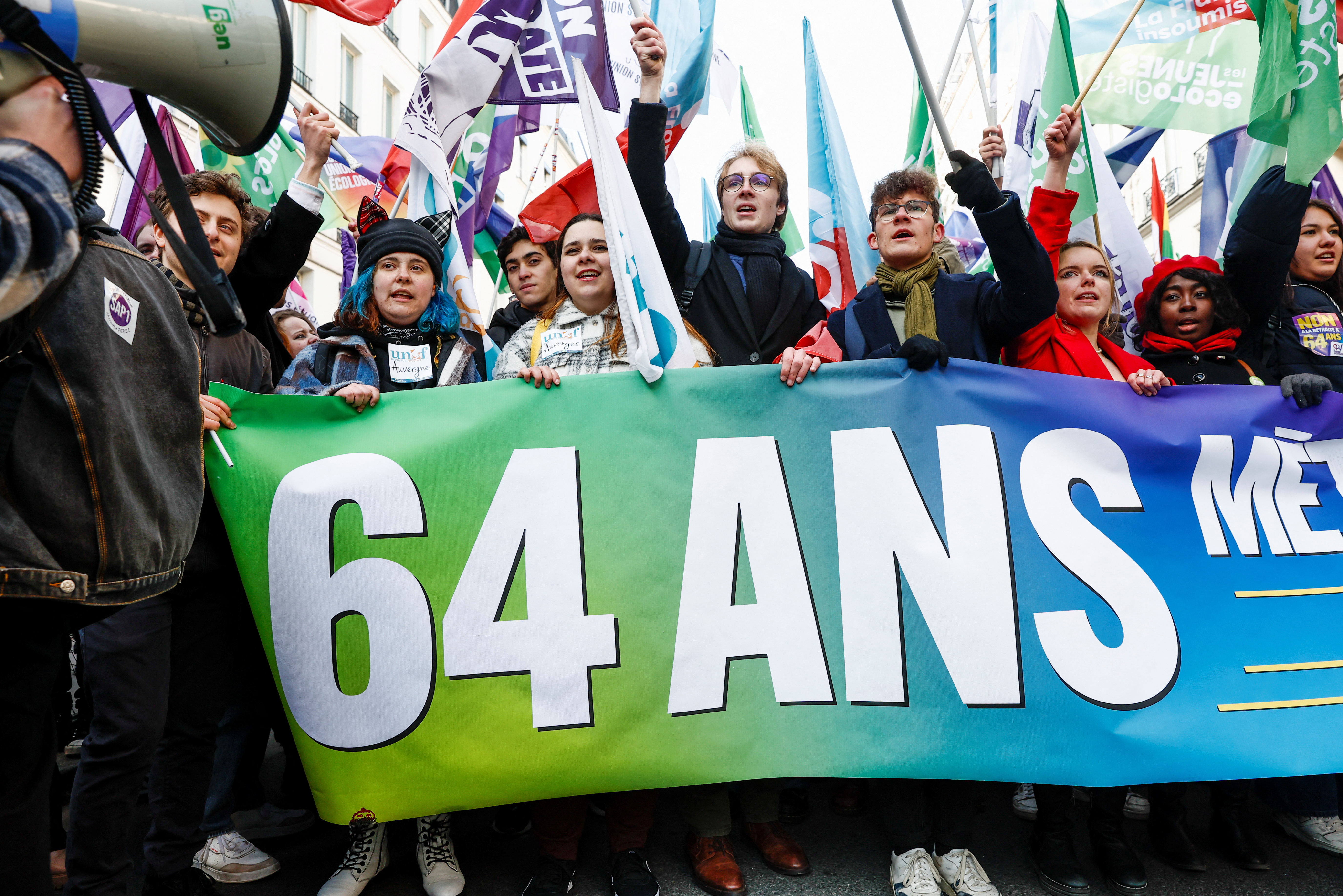 Jóvenes cargan una pancarta que dice "No al retiro a los 64 años" durante una protesta en París (Reuters)