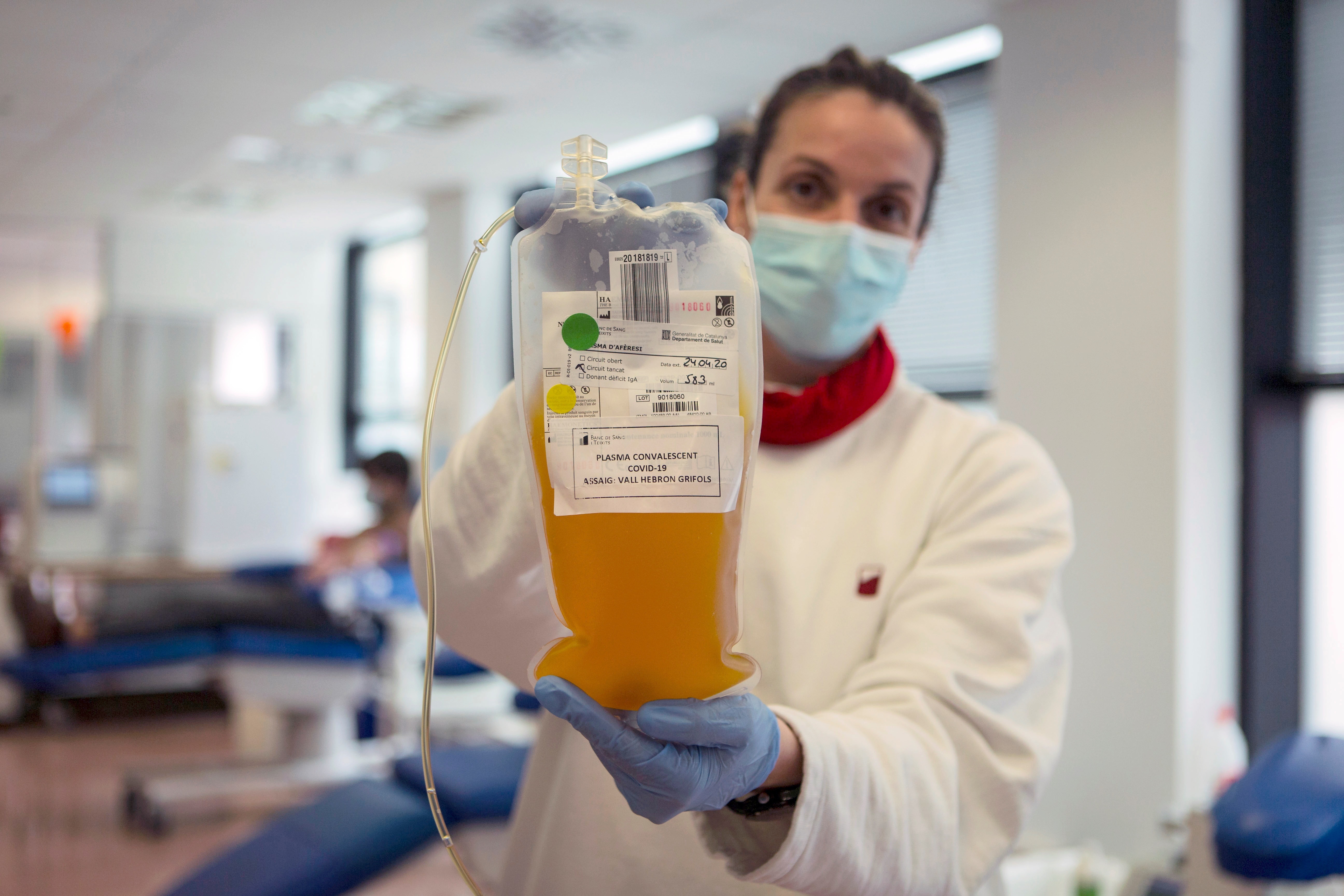 Una enfermera muestra una bolsa de plasma convaleciente extraida a un paciente recuperado de COVID (EFE)
