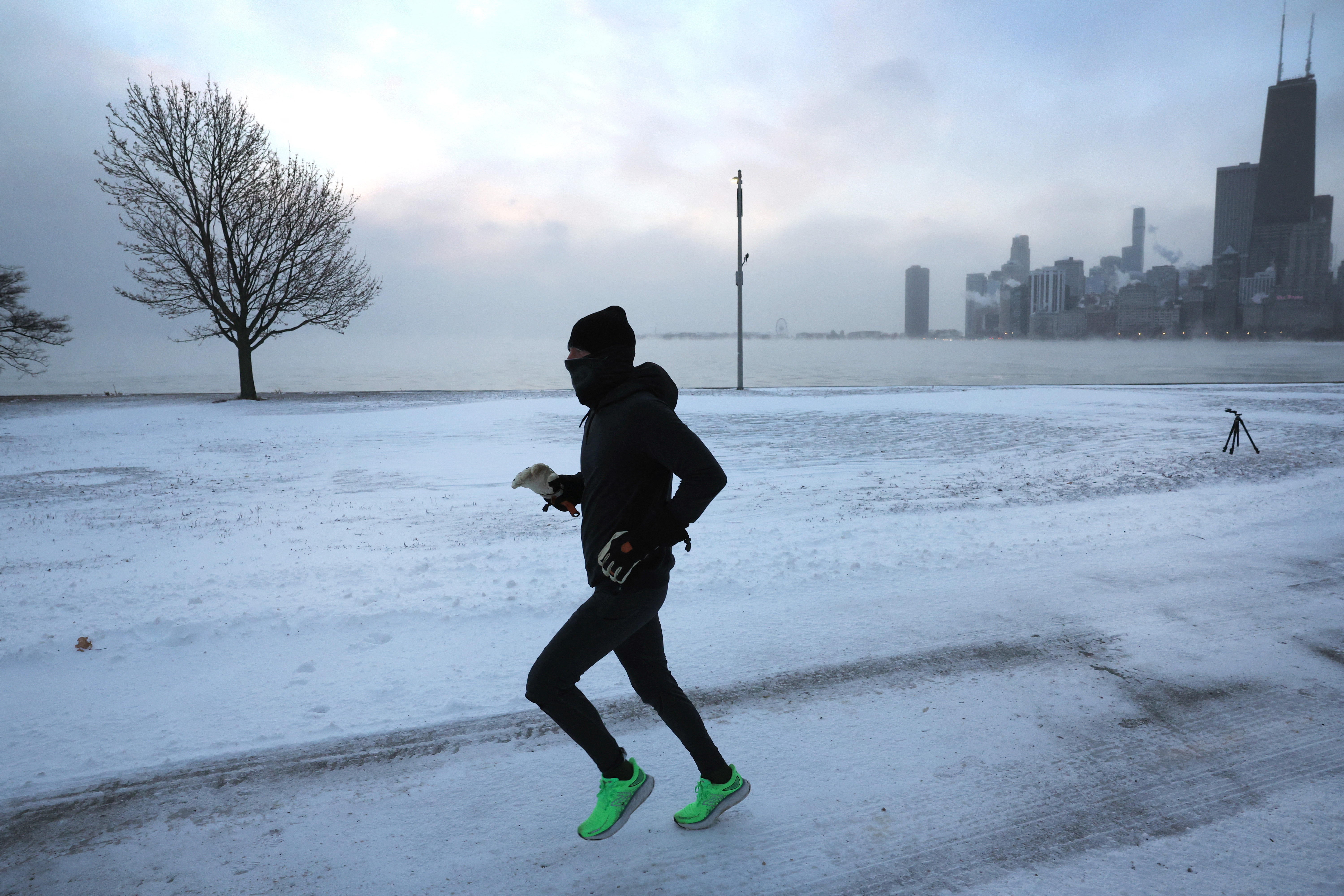 Un corredor corre a lo largo del lago Michigan al amanecer mientras las temperaturas rondan los -8 grados el 22 de diciembre de 2022 en Chicago, Illinois