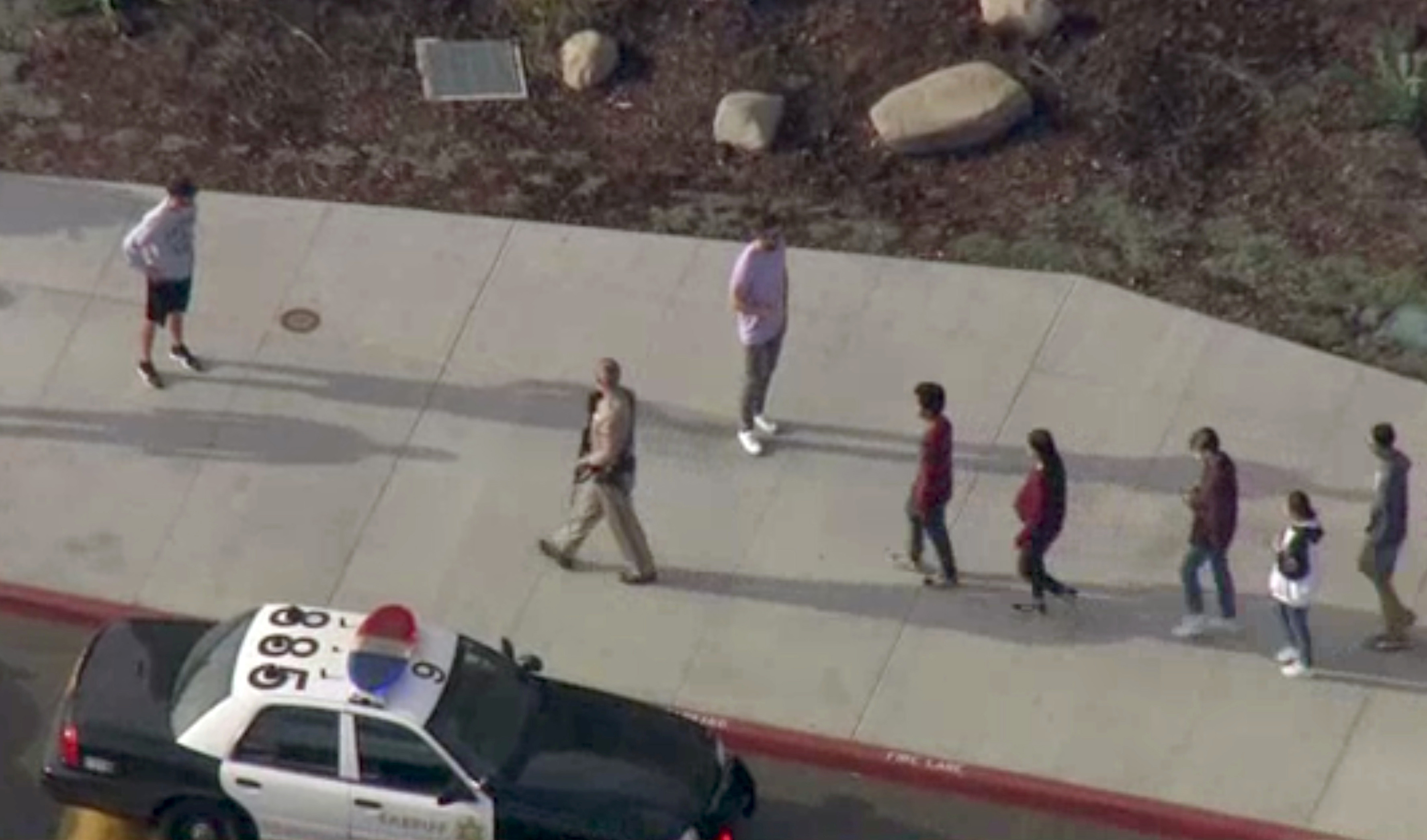 Un oficial guiando a un grupo de estudiantes de la escuela Saugus, en Santa Clarita, California, el 14 de noviembre de 2019 (NBCLA via REUTERS)