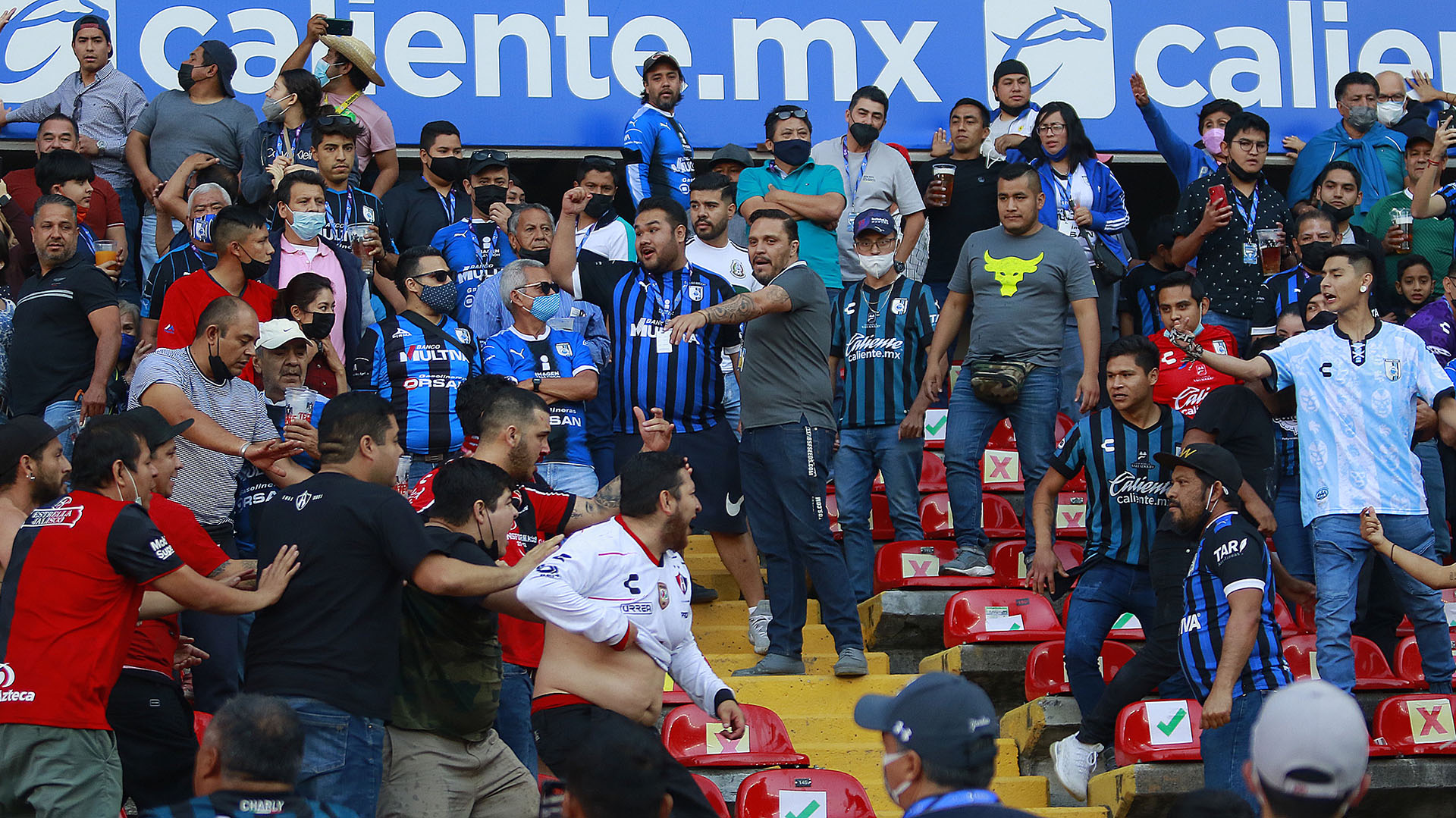 Aficionados de Querétaro y Atlas se enfrentaron al minuto 62, donde familias tuvieron que ser resguardadas en la cancha, durante un juego correspondiente a la jornada 9 del Torneo Clausura 2022 de la Liga MX del fútbol mexicano en el estadio Corregidora de la ciudad de Querétaro (México). (Foto: Enrique Contla/EFE)