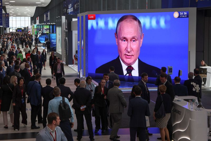 Los participantes se reúnen cerca de una pantalla que muestra al presidente ruso, Vladimir Putin, que pronuncia un discurso en el Foro Económico Internacional de San Petersburgo (SPIEF) en San Petersburgo, Rusia, el 17 de junio de 2022. REUTERS/Anton Vaganov