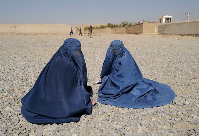 Mujeres afganas desplazadas esperan para recibir la ayuda de la agencia ACNUR frente al centro de distribución en las afueras de Kabul, Afganistán