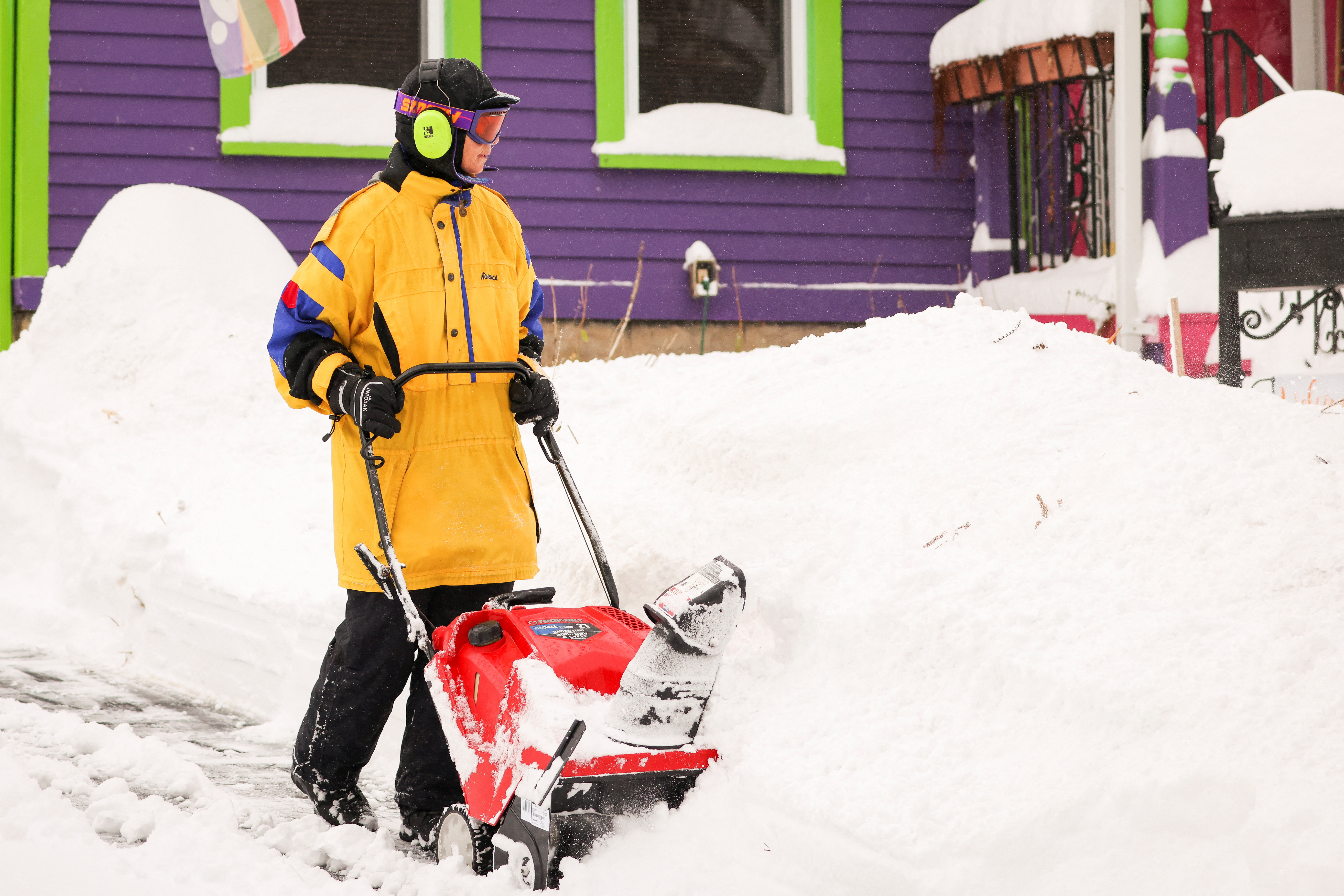 Una persona utiliza un soplador de nieve para limpiar el camino de entrada a su hogar en Buffalo el 19 de noviembre de 2022