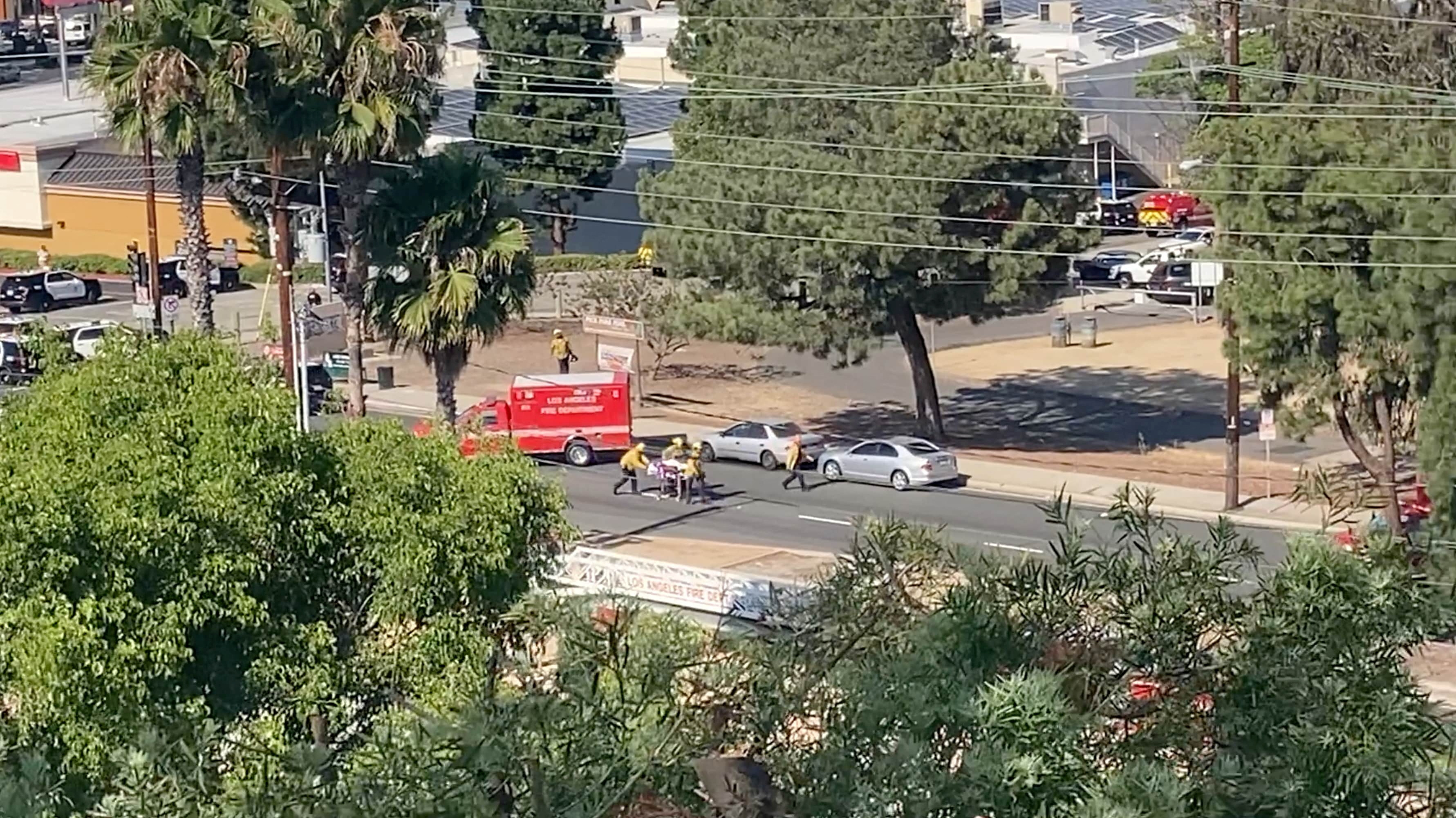 El personal de emergencia carga una camilla luego de un tiroteo en Peck Park, San Pedro, Los Ángeles, California, EEUU